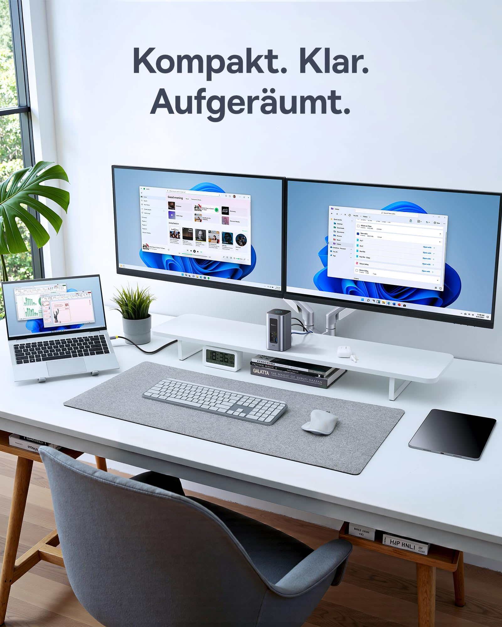 Ein ordentlicher Arbeitsplatz mit zwei großen Monitoren, Laptop, Tastatur und grauem Mauspad auf einem weißen Tisch.