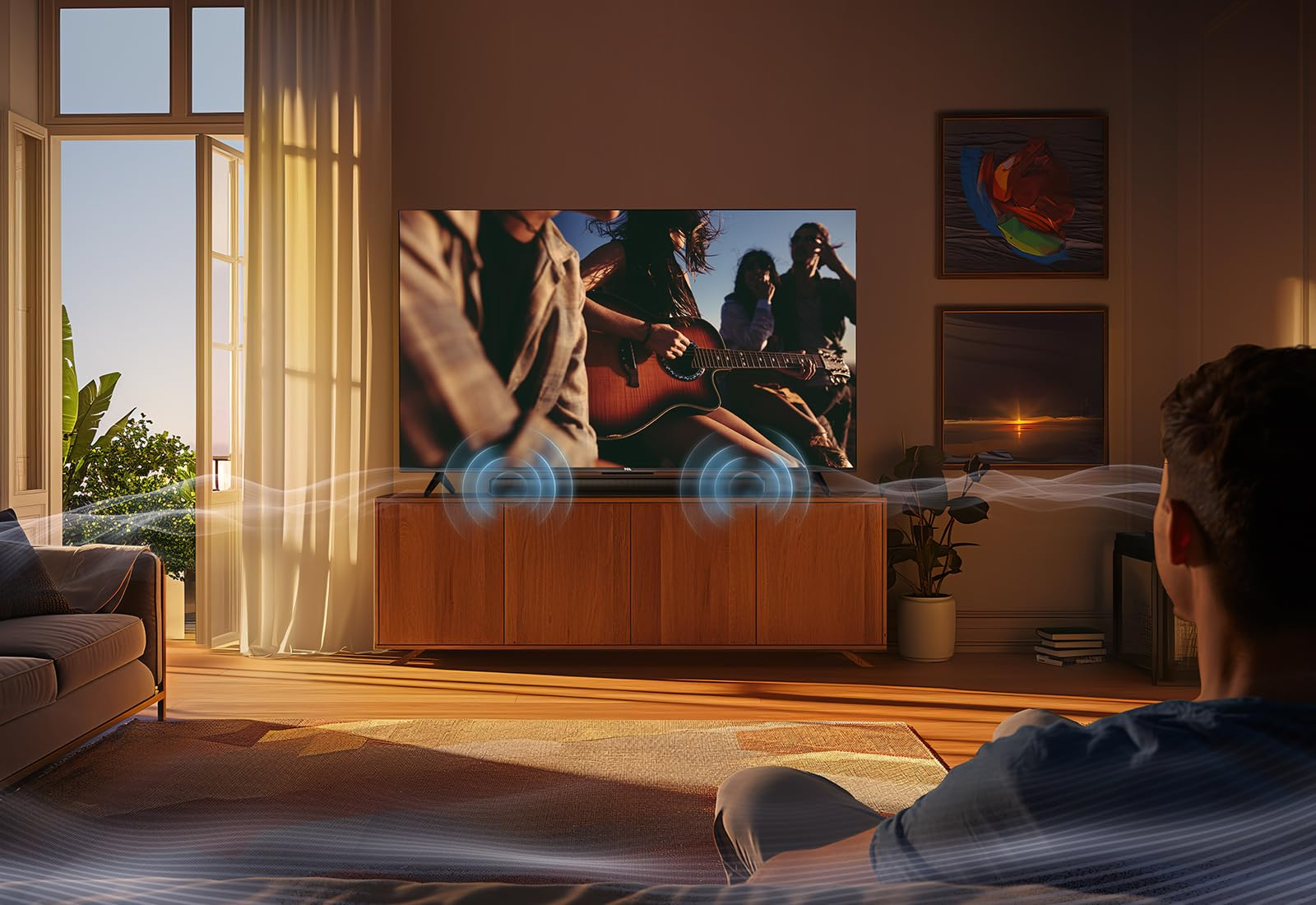 Ein Mann sitzt in einem sonnigen Wohnzimmer und schaut fern, während blaue Klangwellen aus dem Fernseher strahlen.