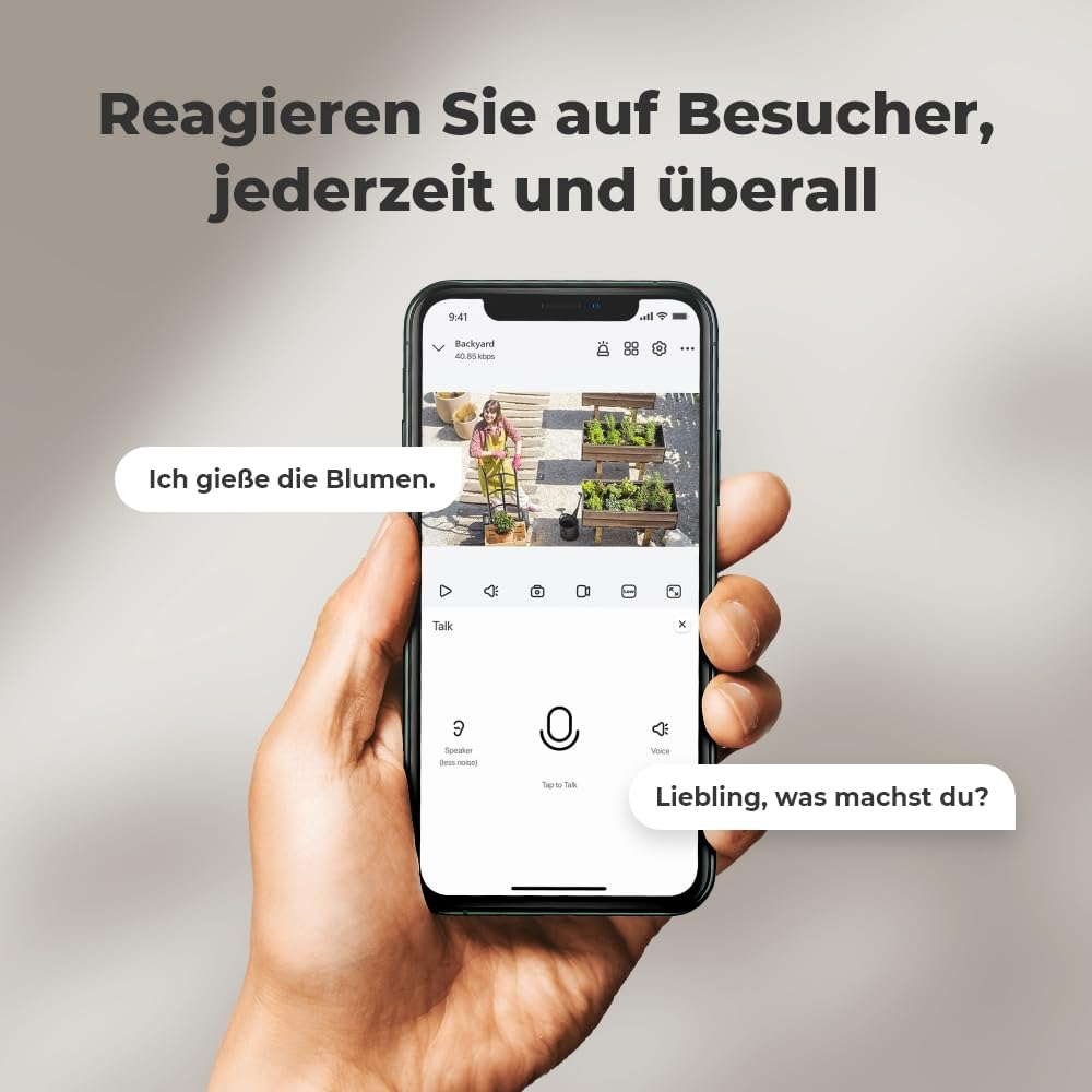 Une main tient un smartphone affichant une application de sécurité avec un jardin.