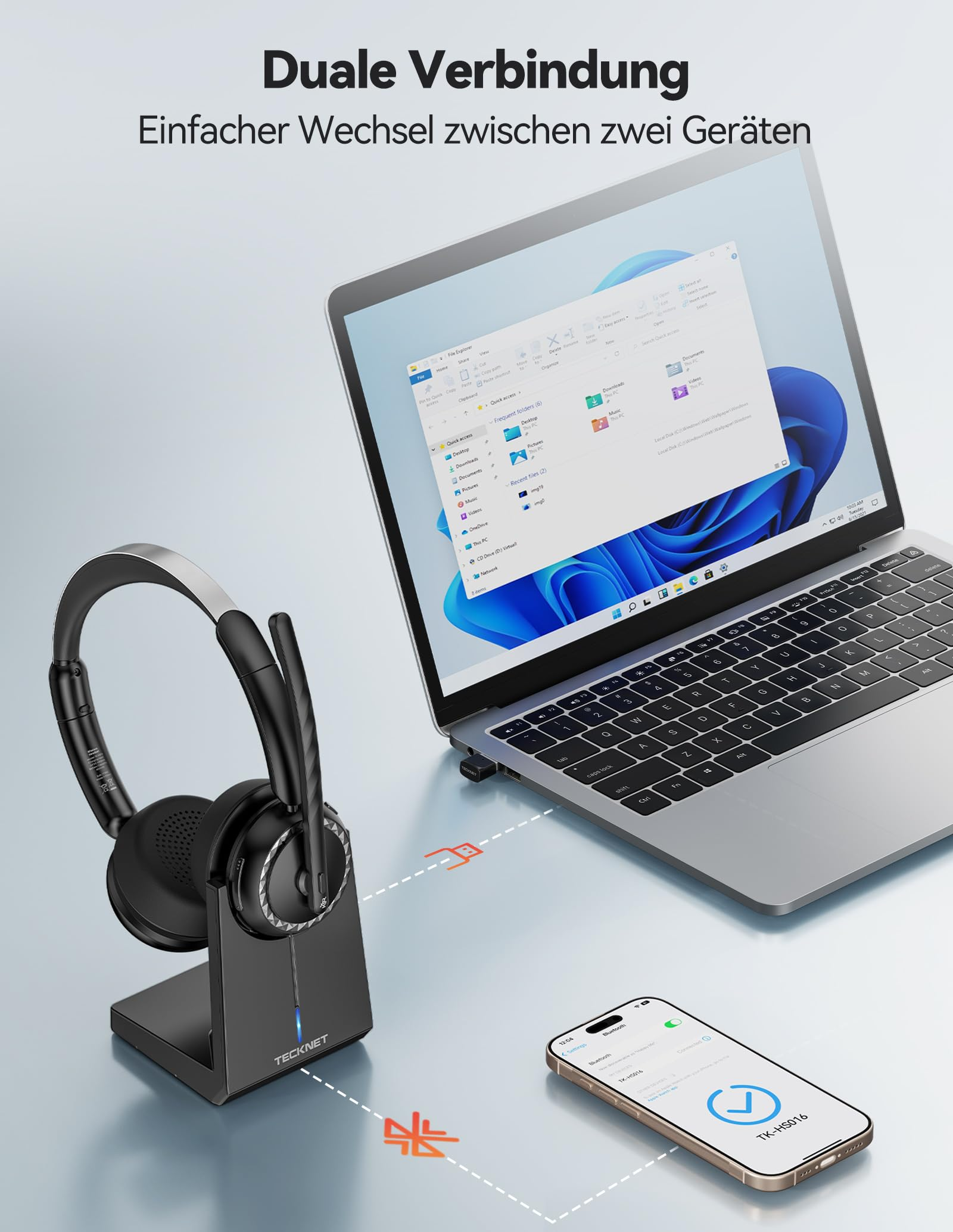 Schwarzes TeckNet Headset auf Ladestation verbunden mit Laptop und Smartphone.
