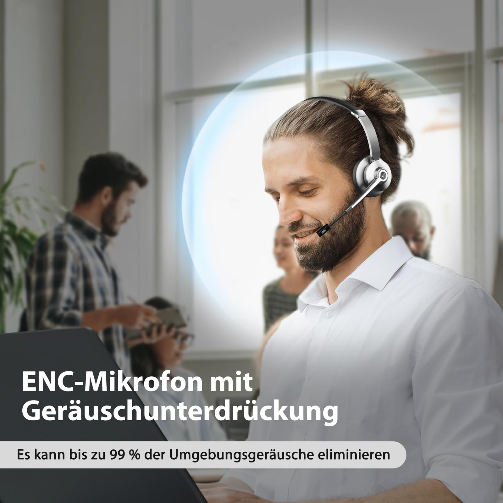 Ein Mann mit Headset arbeitet im Büro vor einem Laptop.