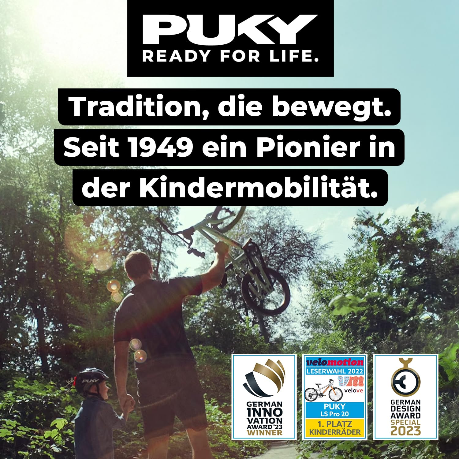 Ein Erwachsener hält ein Kinderfahrrad in die Luft, neben einem Kind im Wald mit Auszeichnungen.