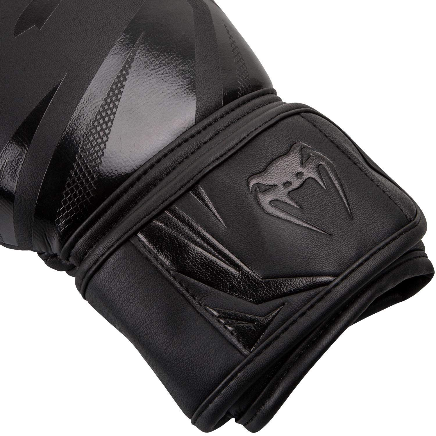 Schwarzer Venum-Boxhandschuh mit geprägtem Logo auf dem Handgelenkriemen.