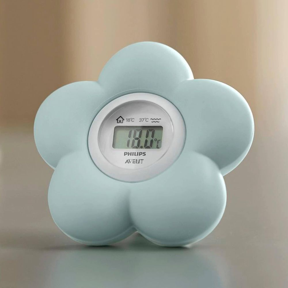Ein hellblaues, blumenförmiges Philips Avent digitales Thermometer auf einer glatten Oberfläche.