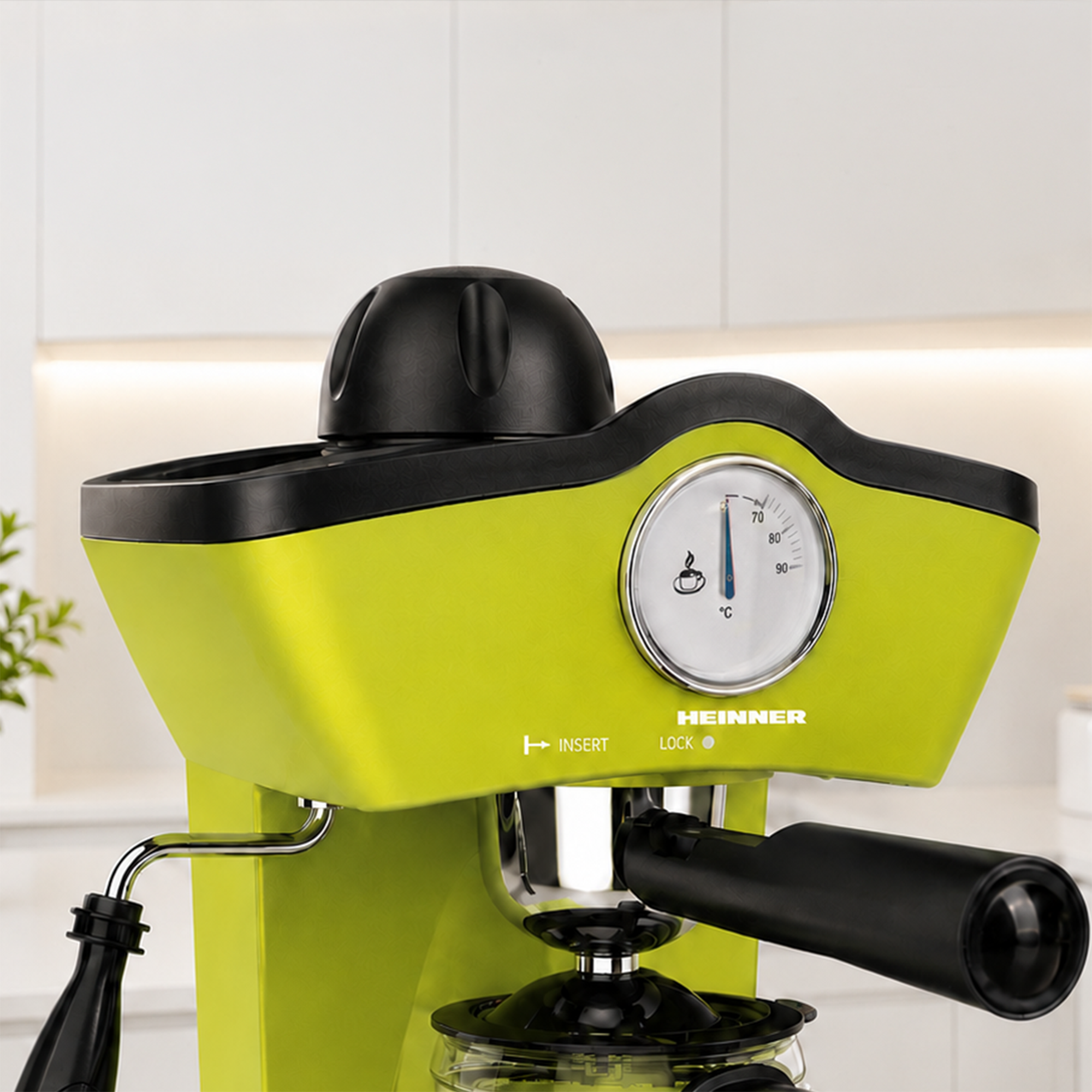 A lime green Heinner espresso machine with a black knob, thermometer, and portafilter in a kitchen.