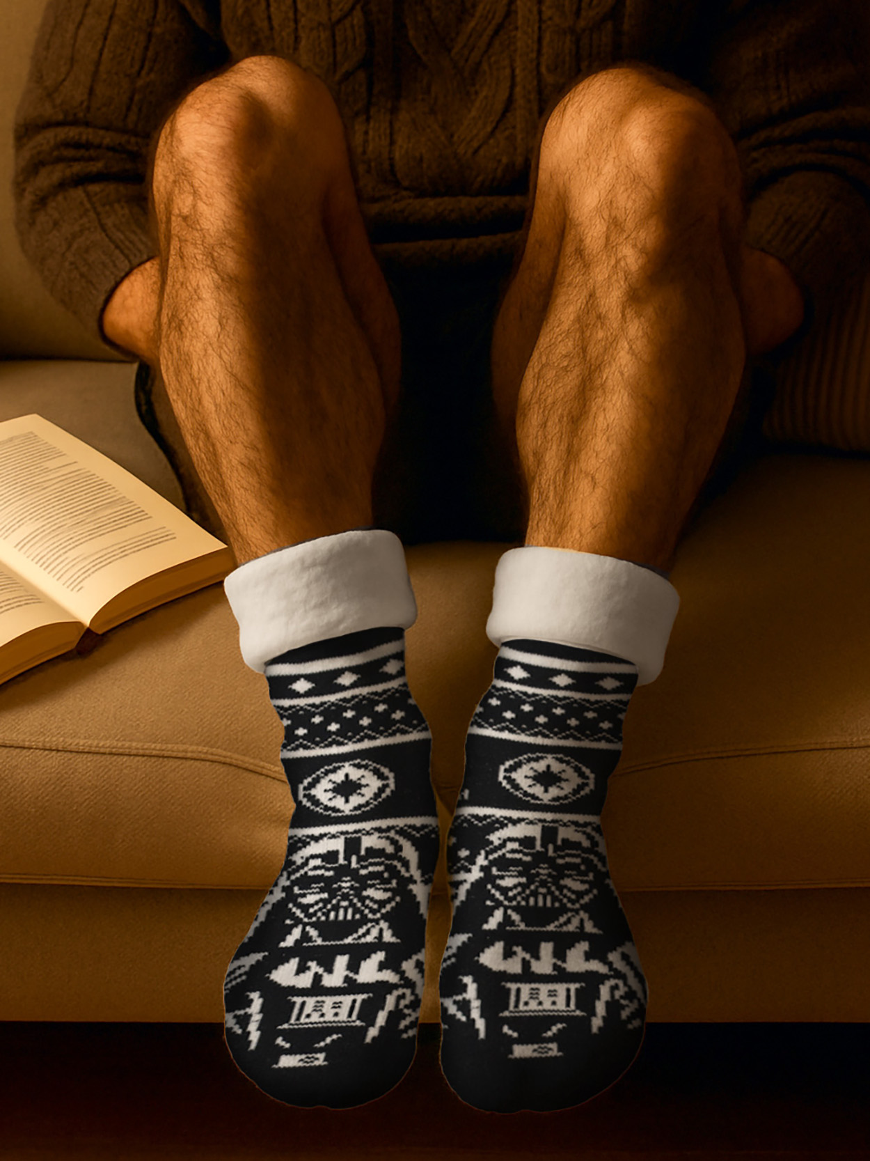 Beine auf einem Sofa mit Darth Vader Socken und einem offenen Buch.