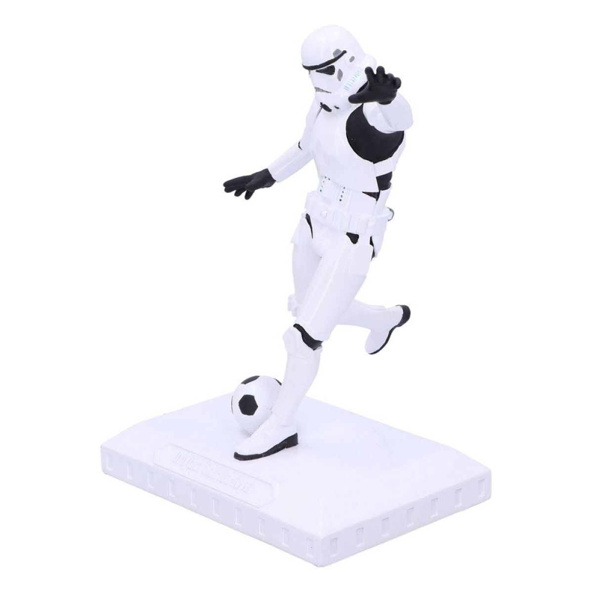 Una figura de stormtrooper con armadura blanca patea un balón de fútbol en una base blanca.