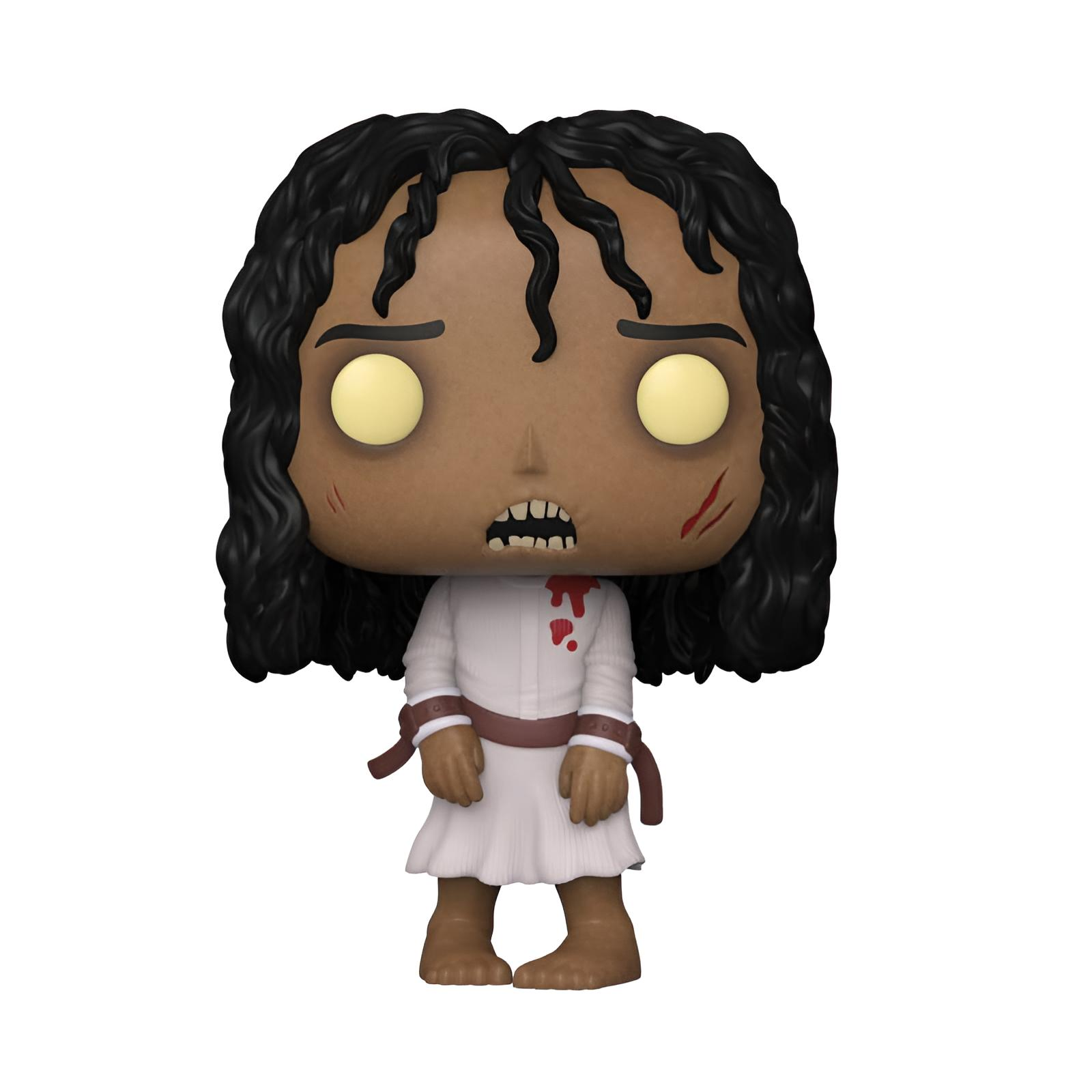 Una figura de vinilo con largo pelo negro, ojos amarillos, vestido blanco con manchas de sangre y correas rojas.