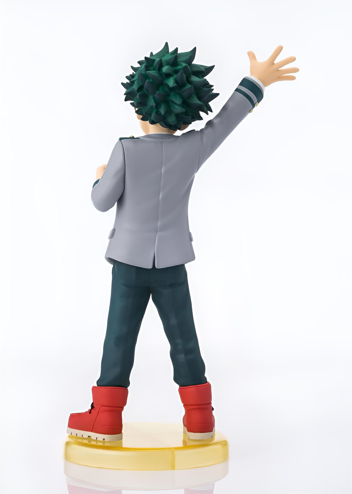 Vista trasera de una figura de anime con cabello verde, chaqueta gris y botas rojas sobre una base amarilla.
