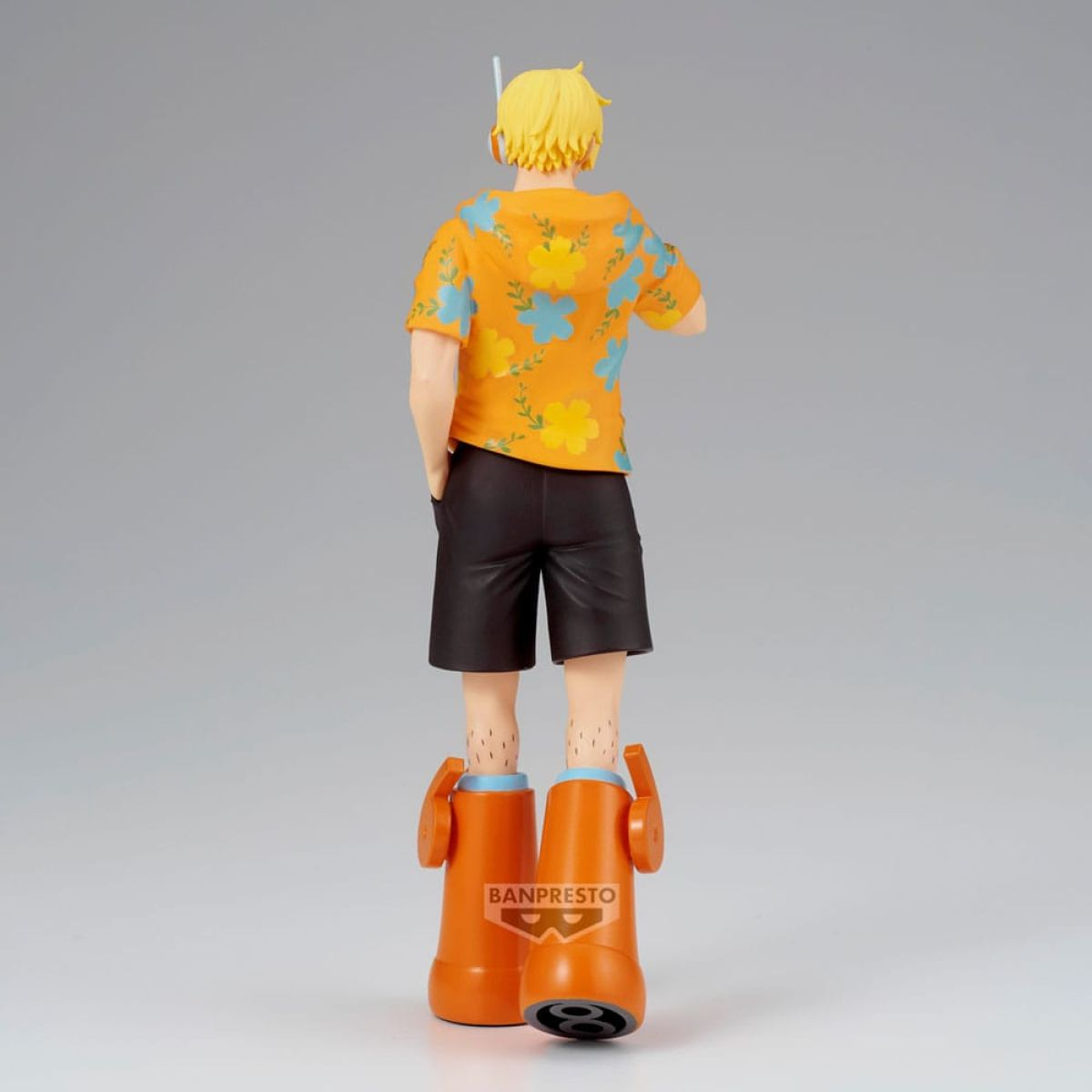 Figura de anime de espaldas con pelo amarillo, camisa floral naranja, pantalones cortos negros y botas grandes.