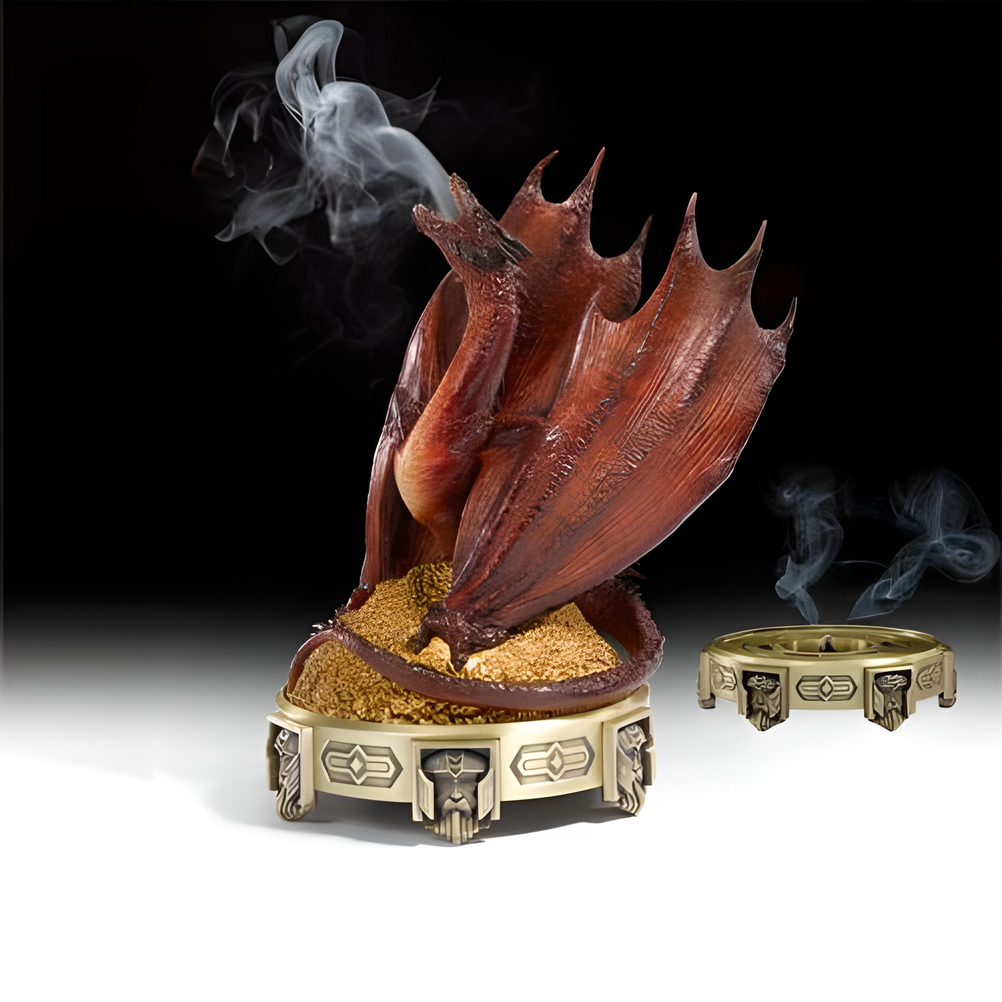 Un dragón rojo sentado en un cuenco dorado exhala humo, junto a una base más pequeña.