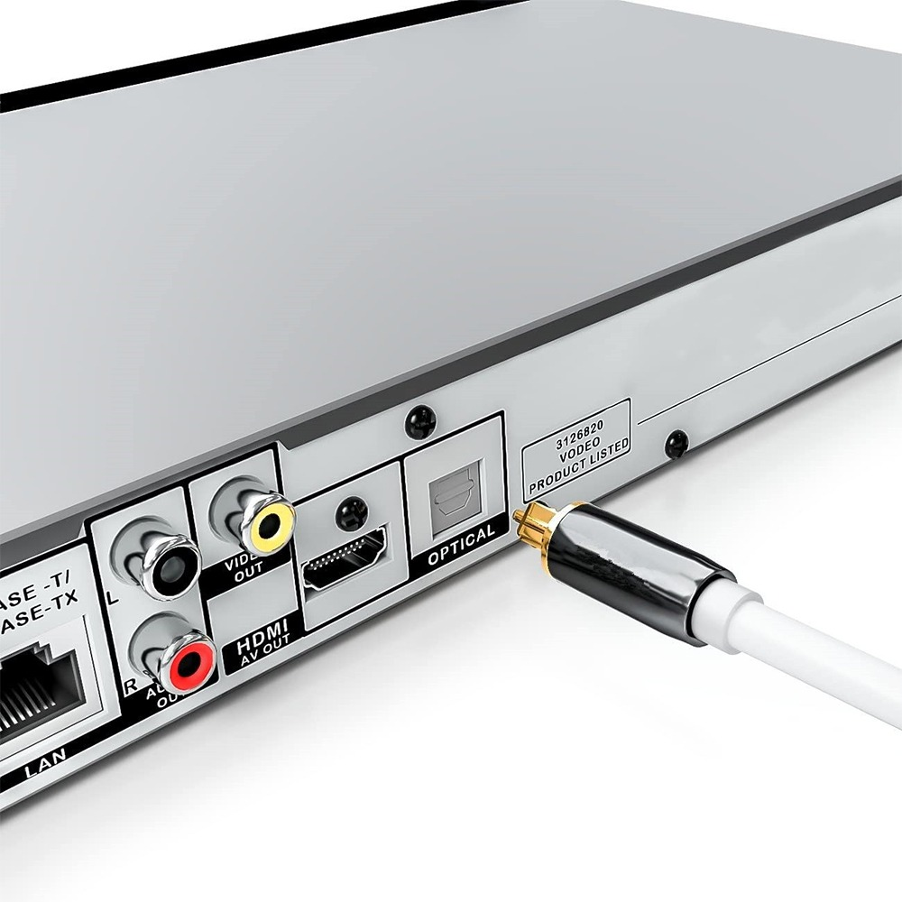 Ein Audiokabel nähert sich dem optischen Anschluss auf der Rückseite eines silbernen Geräts.