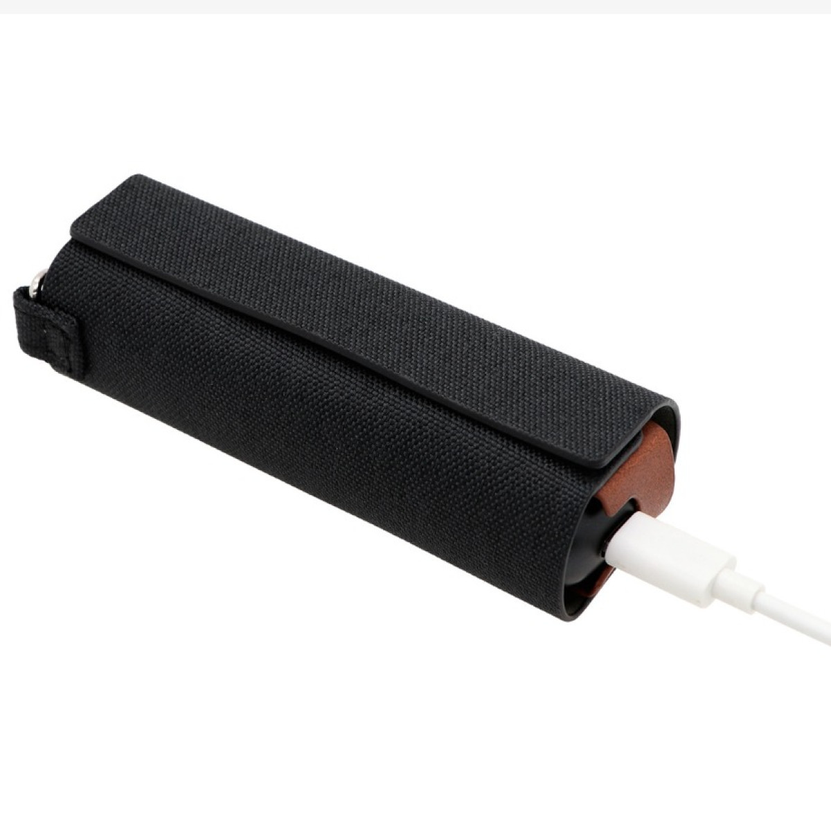 Eine schwarze Stoff-Powerbank mit braunen Lederdetails ist auf weißem Hintergrund an ein weißes Ladekabel angeschlossen.