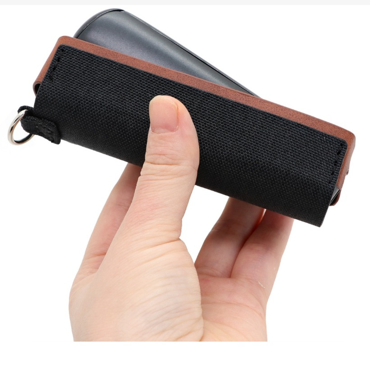 Eine Hand hält eine schwarze und braune elektronische Zigarettenetui auf weißem Hintergrund.
