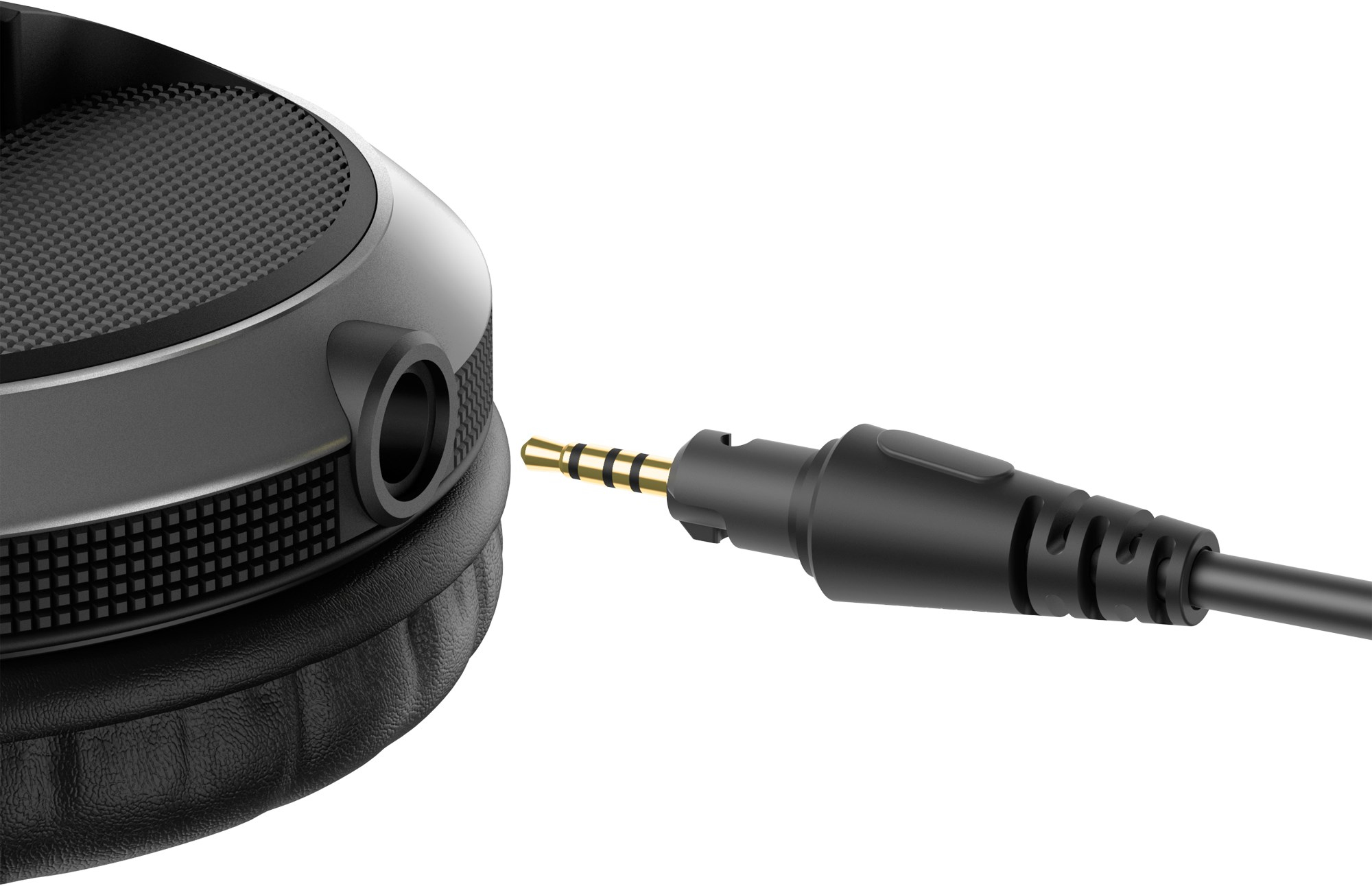 Un cable de audio con un jack dorado se acerca al conector de unos auriculares negros.