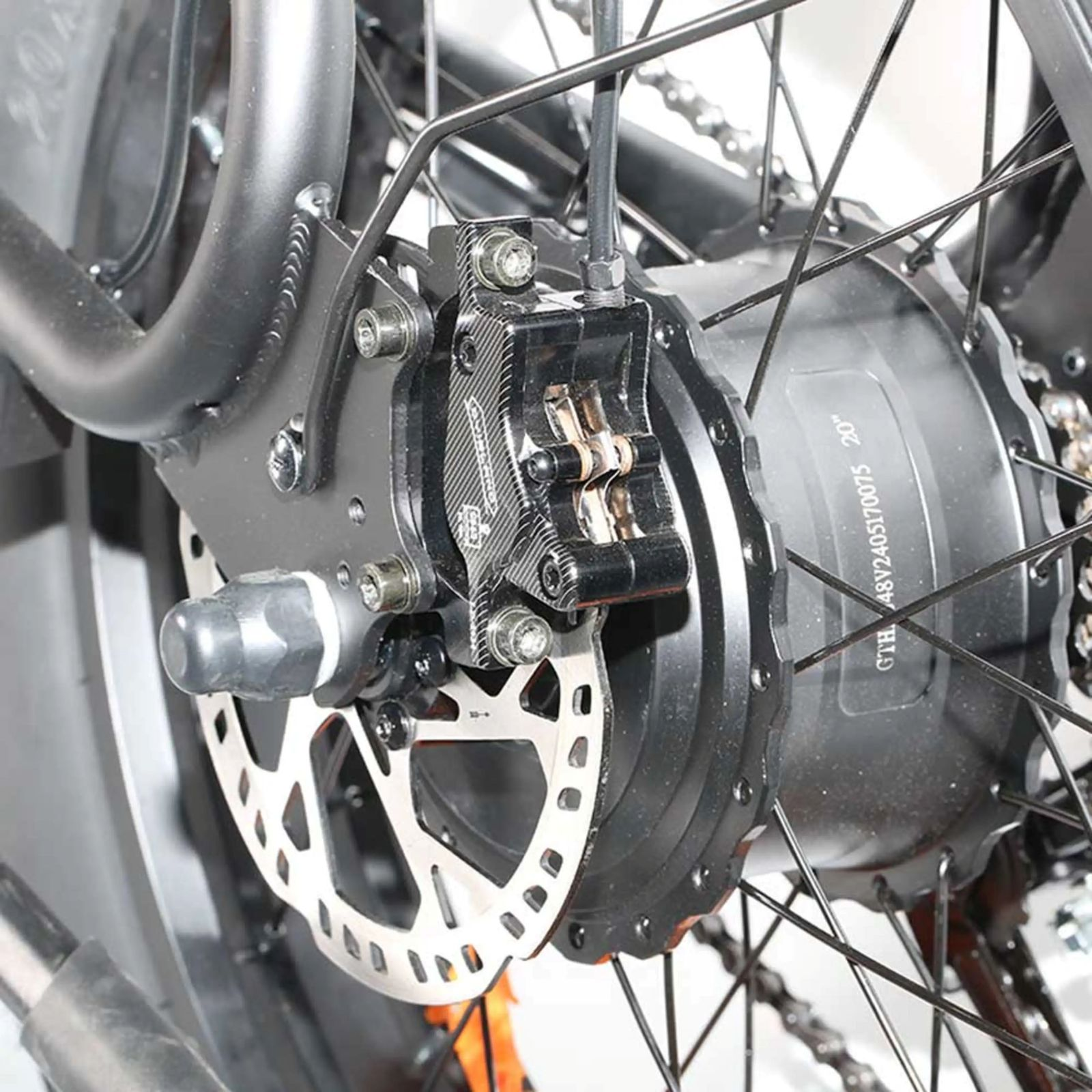 Primer plano de una pinza de freno de disco hidráulica y rotor de bicicleta en el buje trasero.