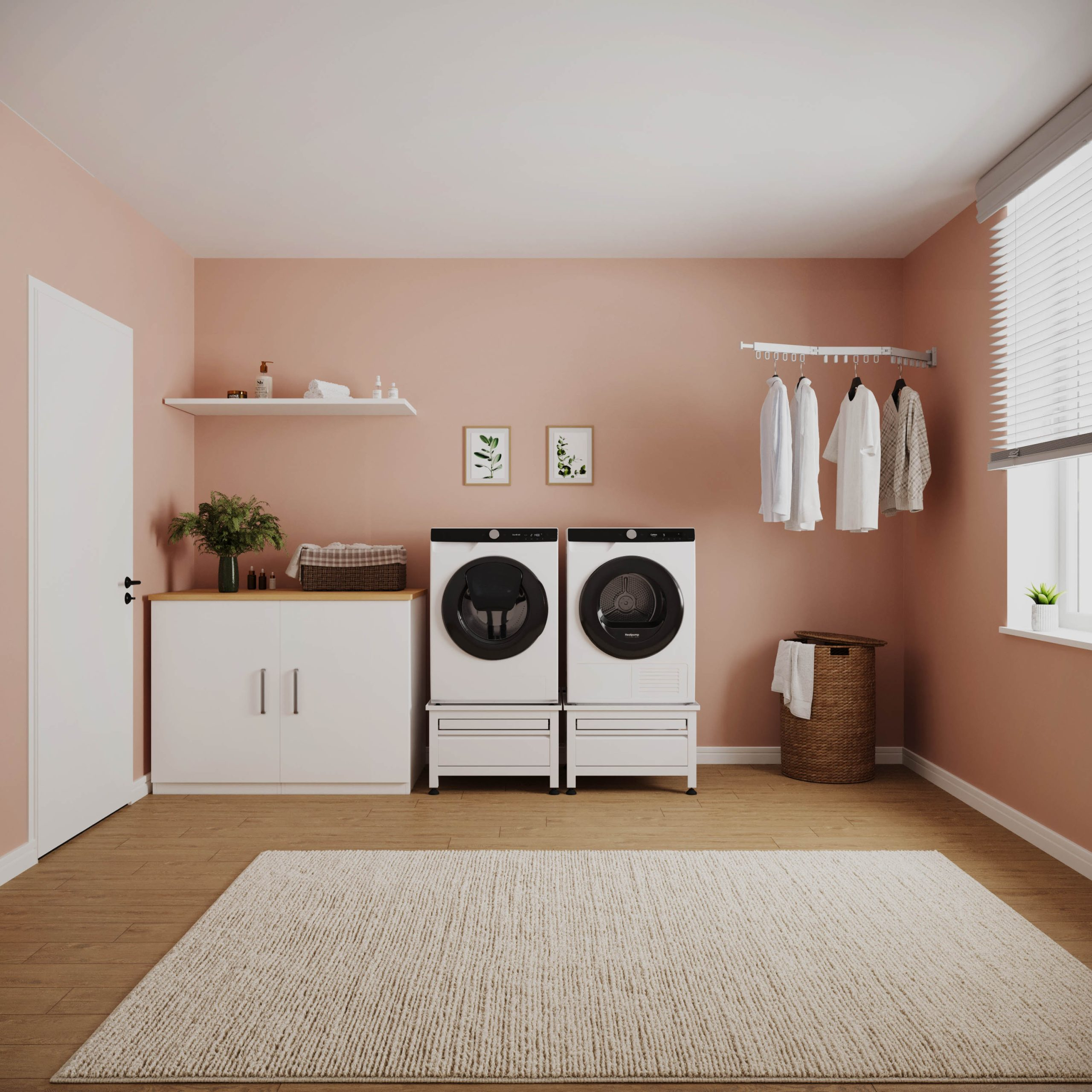 Modern pastel pink laundry room with washer, dryer, white cabinets, hanging clothes, and a light rug on a wood floor.