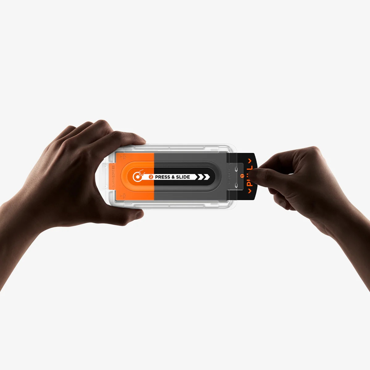 Hands hold a screen protector installation tray while one hand pulls the tab.