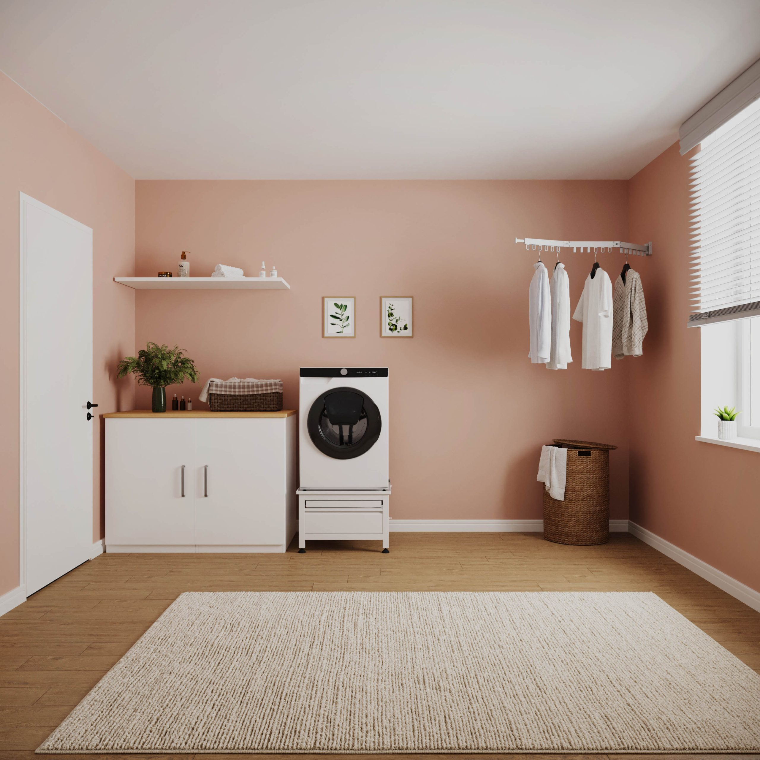 A modern laundry room with peach walls, white cabinets, a washing machine, a large rug, and hanging clothes.