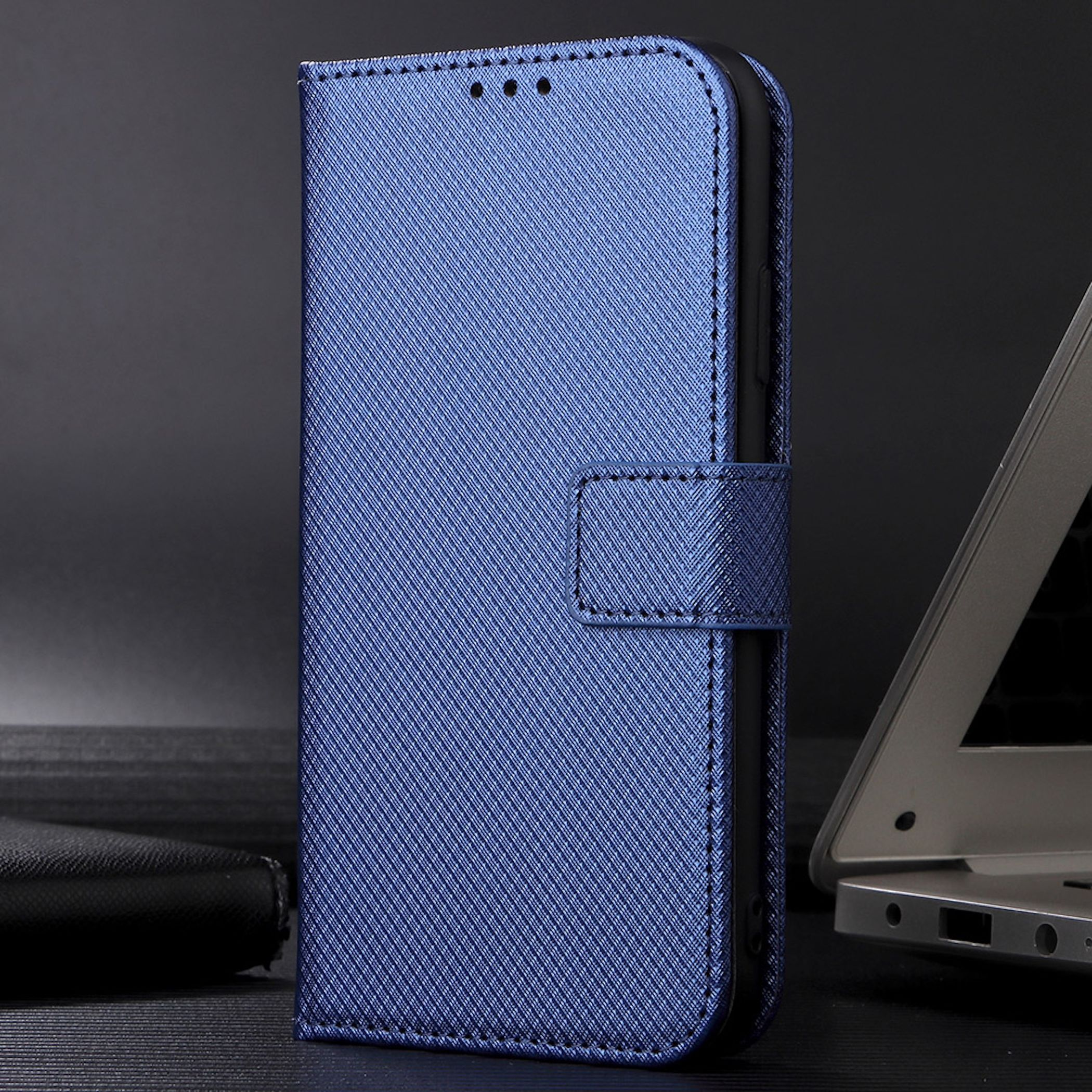 Blaue Handytasche im Buchdesign mit strukturierter Oberfläche auf dunklem Untergrund.