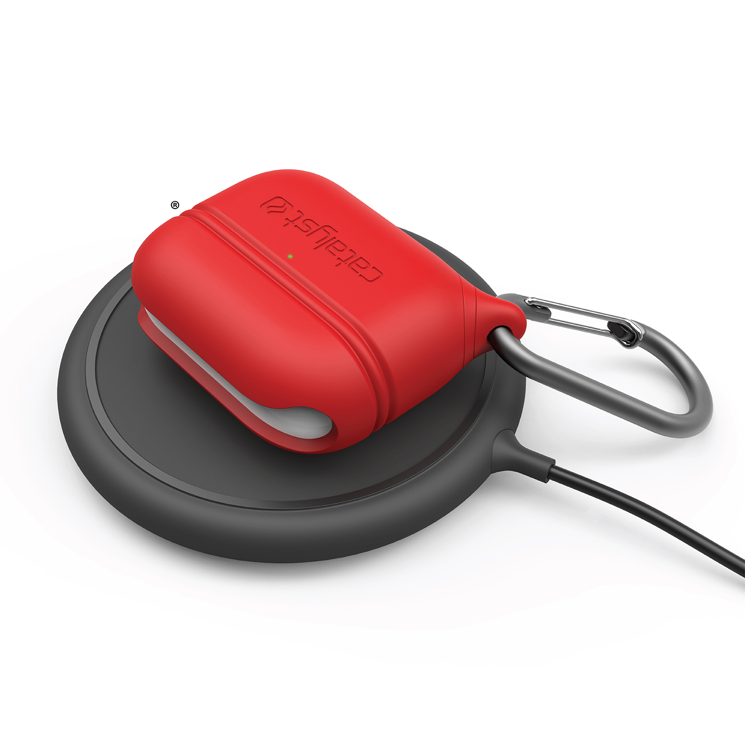 Ein rotes AirPods-Case mit Karabiner liegt auf einer schwarzen kabellosen Ladestation.