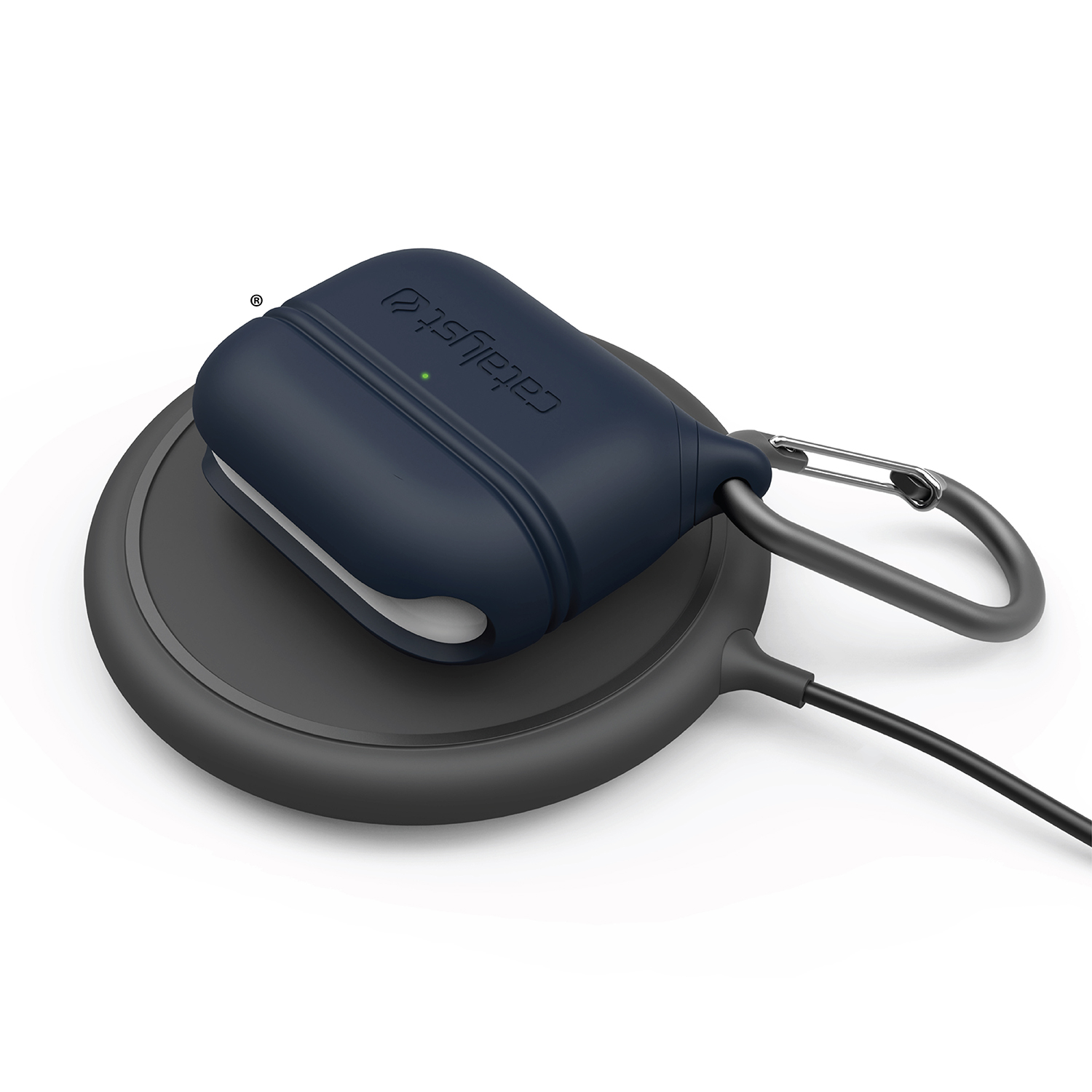 Eine dunkelblaue Catalyst AirPods-Hülle lädt auf einem schwarzen Wireless-Pad mit Karabiner.