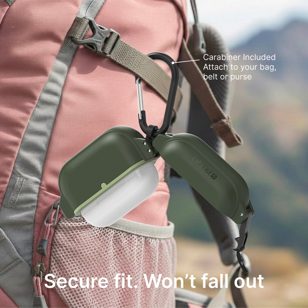 Grünes Case mit Karabiner, an einem rosa Rucksack befestigt.