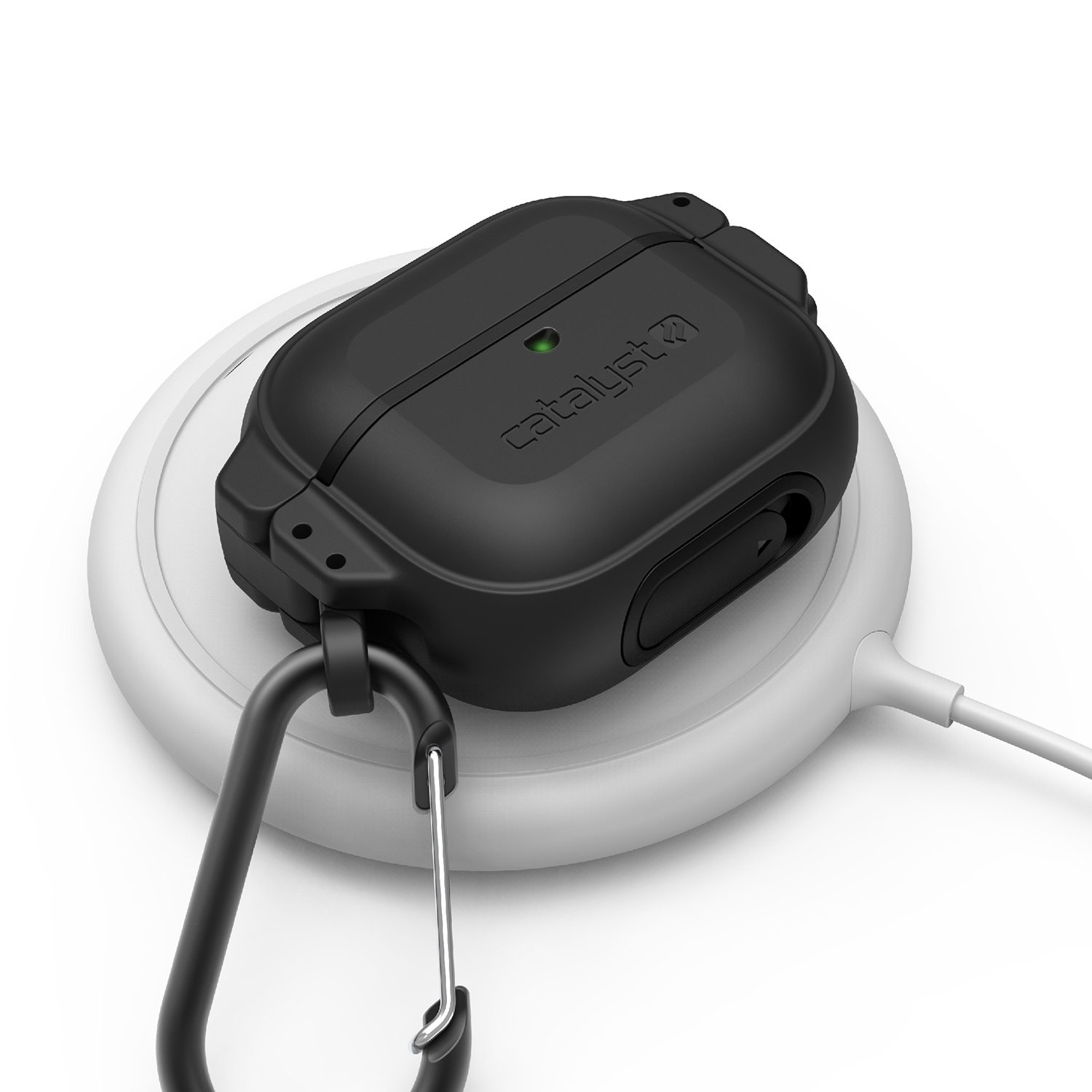 Eine schwarze Catalyst-Hülle für AirPods liegt mit einem Karabiner auf einem runden, weißen Ladegerät.