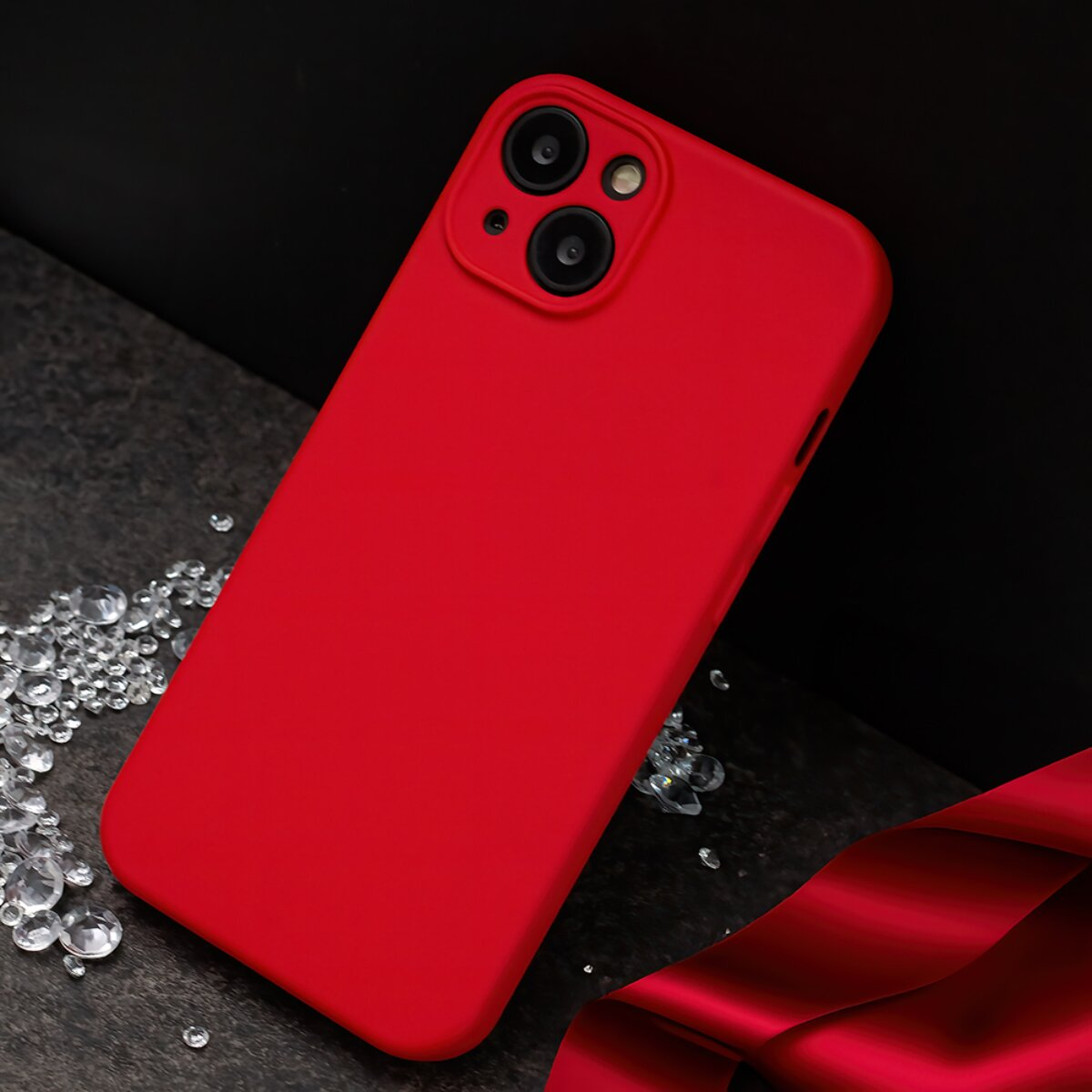 Eine rote Smartphone-Hülle auf dunkler Oberfläche, umgeben von funkelnden Kristallen.