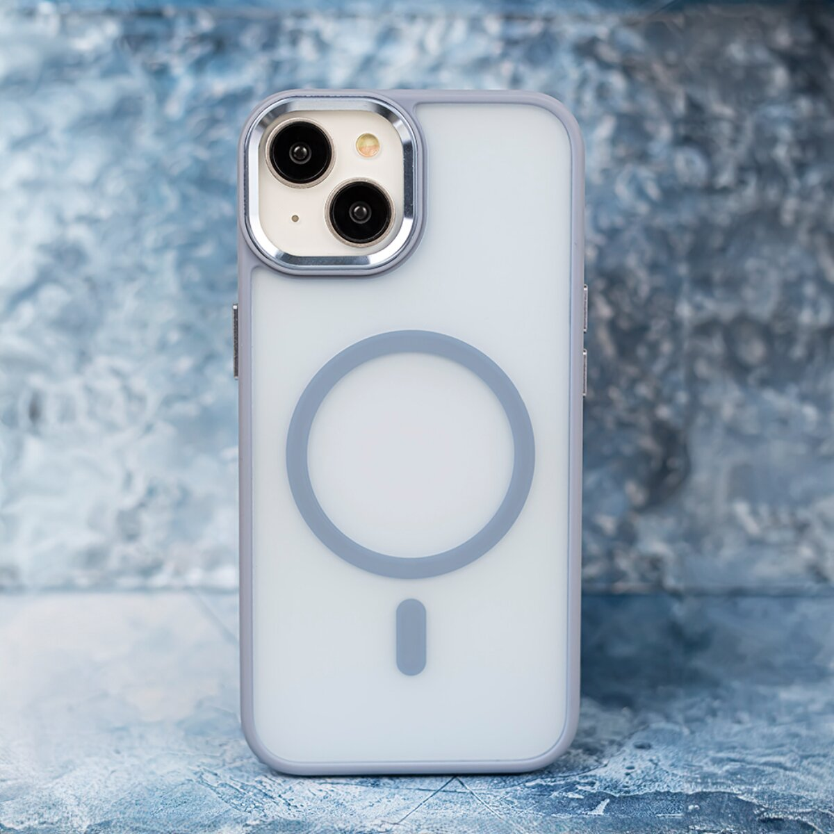 Ein blaues Smartphone mit MagSafe-Hülle steht auf blauem, strukturiertem Untergrund.