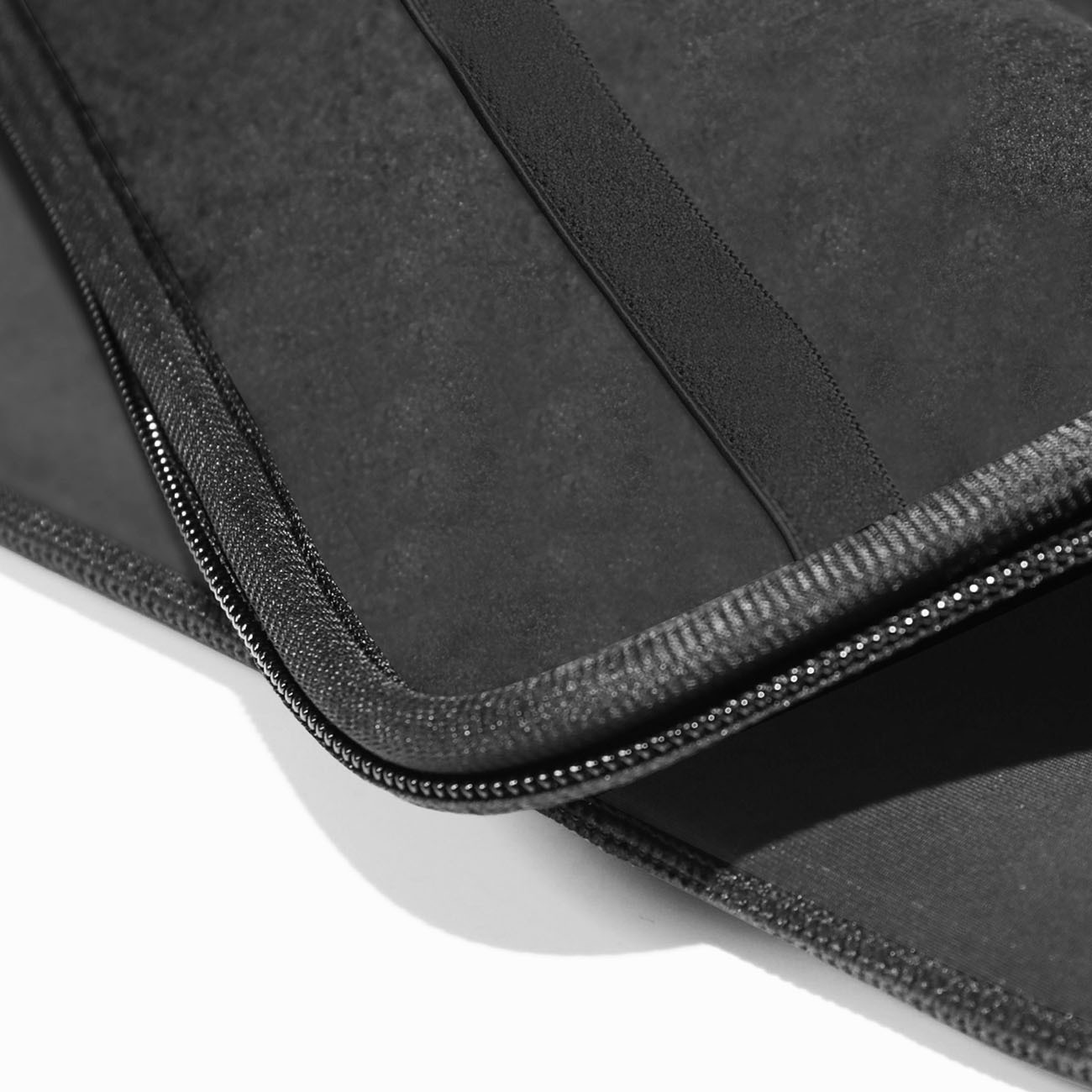 Primo piano di una custodia in neoprene nero con cerniera aperta.
