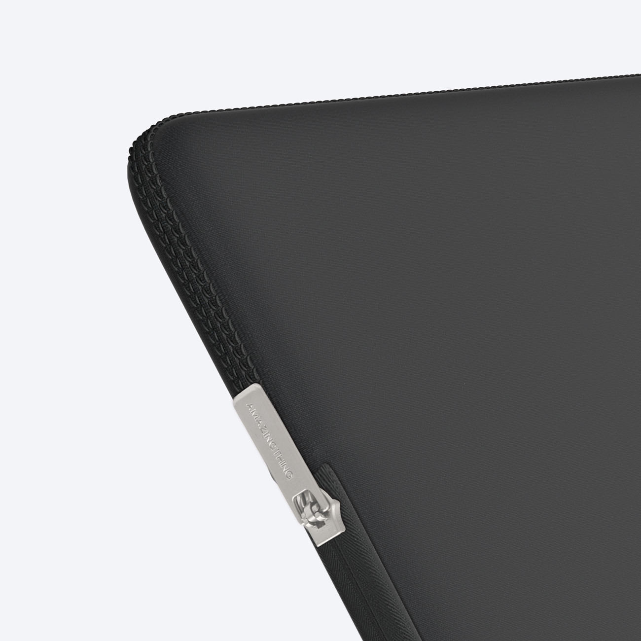 Primo piano di una custodia nera per laptop con zip argentata e marchio.