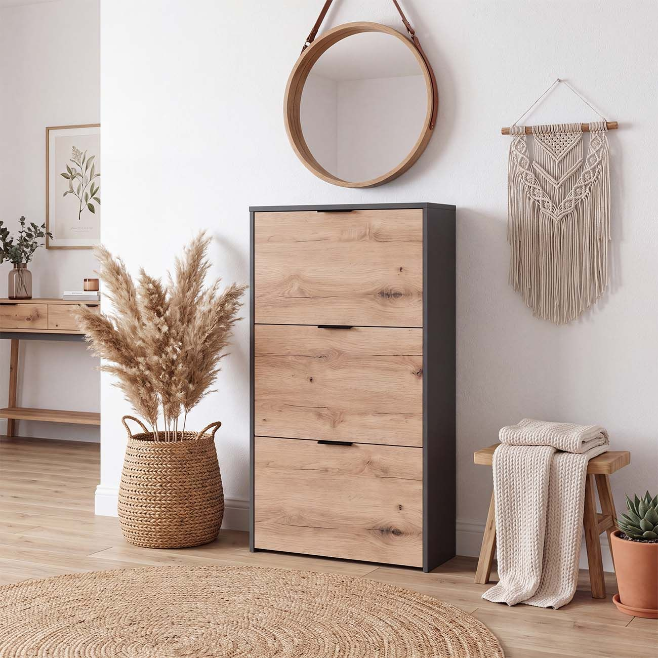 Un zapatero de madera con tres puertas abatibles se encuentra en un pasillo moderno con espejo redondo y decoración.