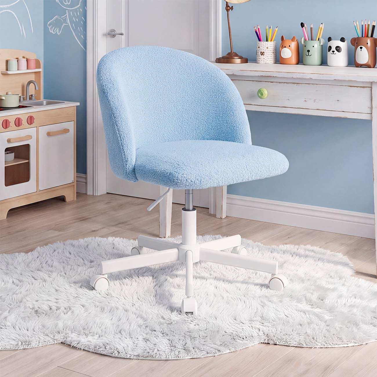 Una silla de oficina azul claro peluda sobre una alfombra blanca y esponjosa frente a un escritorio en una habitación infantil.