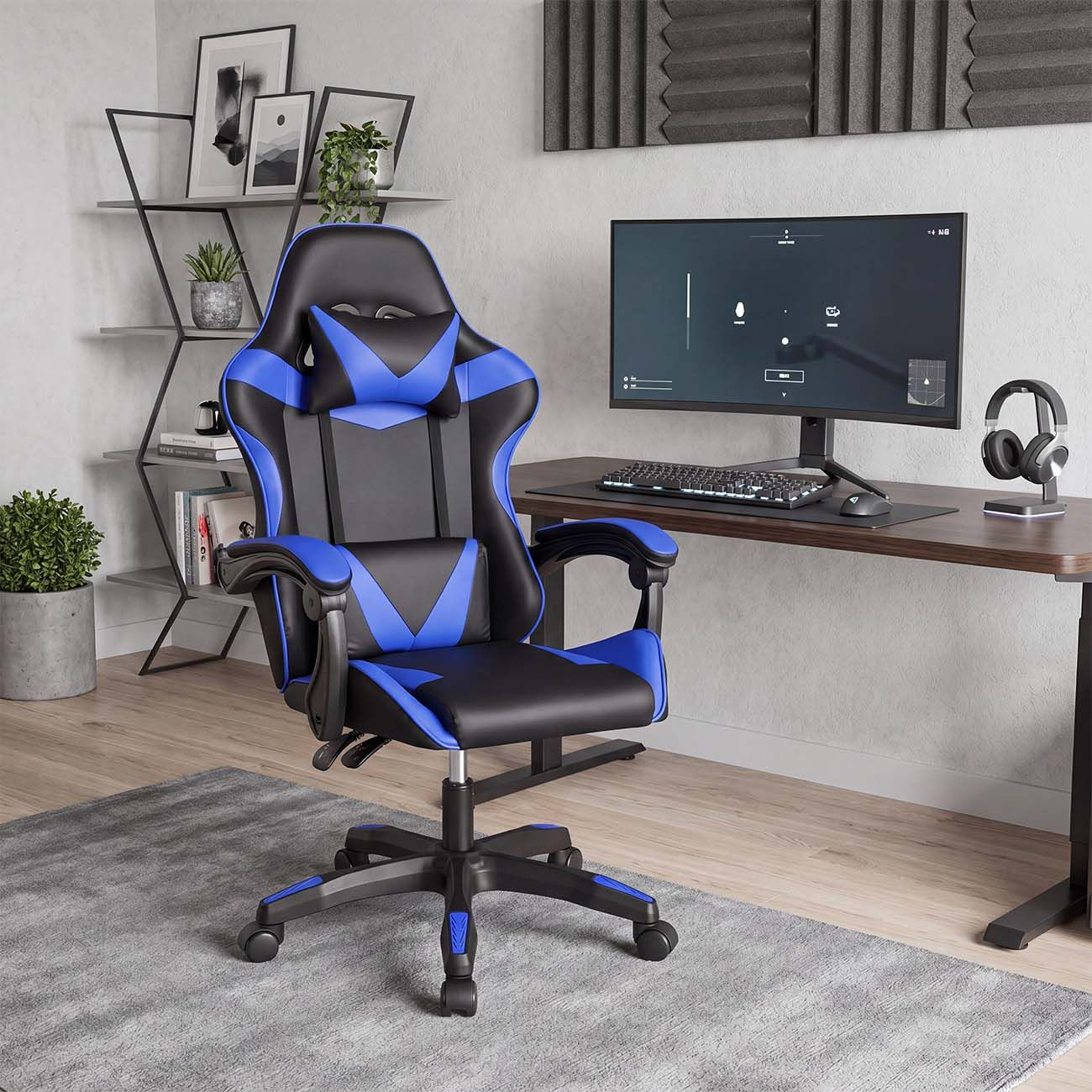Una silla de juego azul y negra está en un escritorio con un monitor en una habitación luminosa.