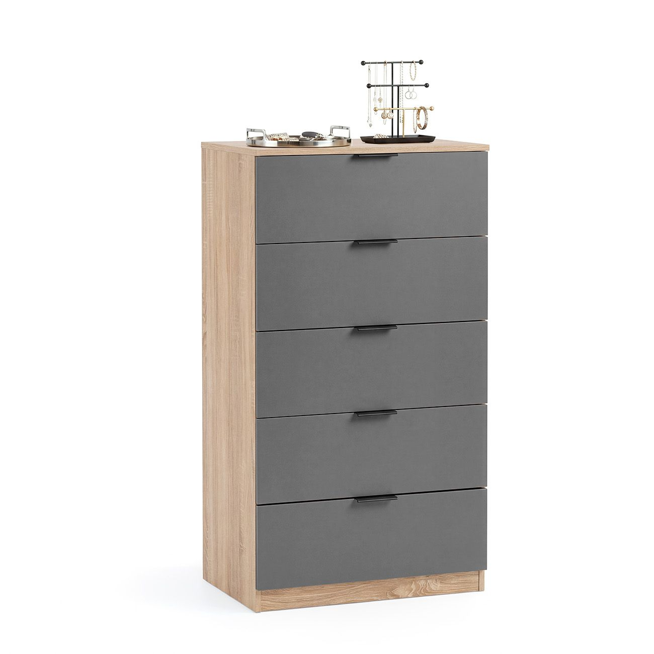 Una cómoda alta de madera con cinco cajones grises y tiradores negros sobre fondo blanco, decorada con accesorios.