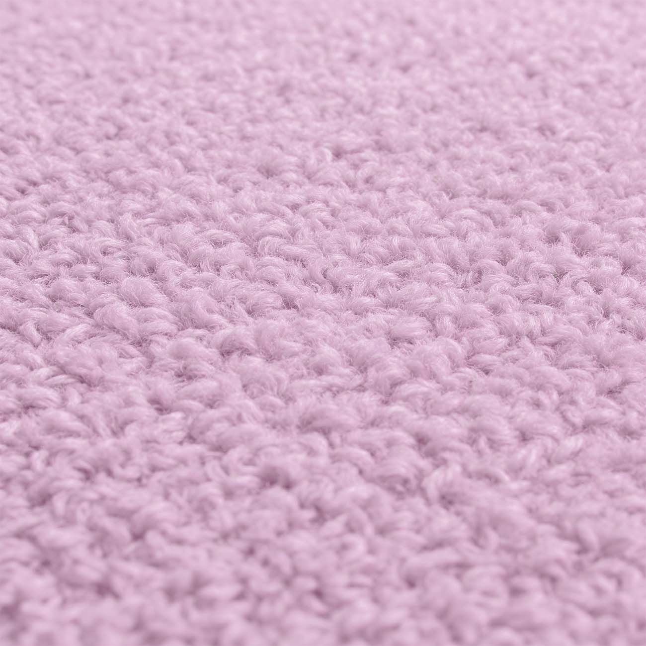 Vista de cerca de una manta tejida de color morado claro y textura suave.