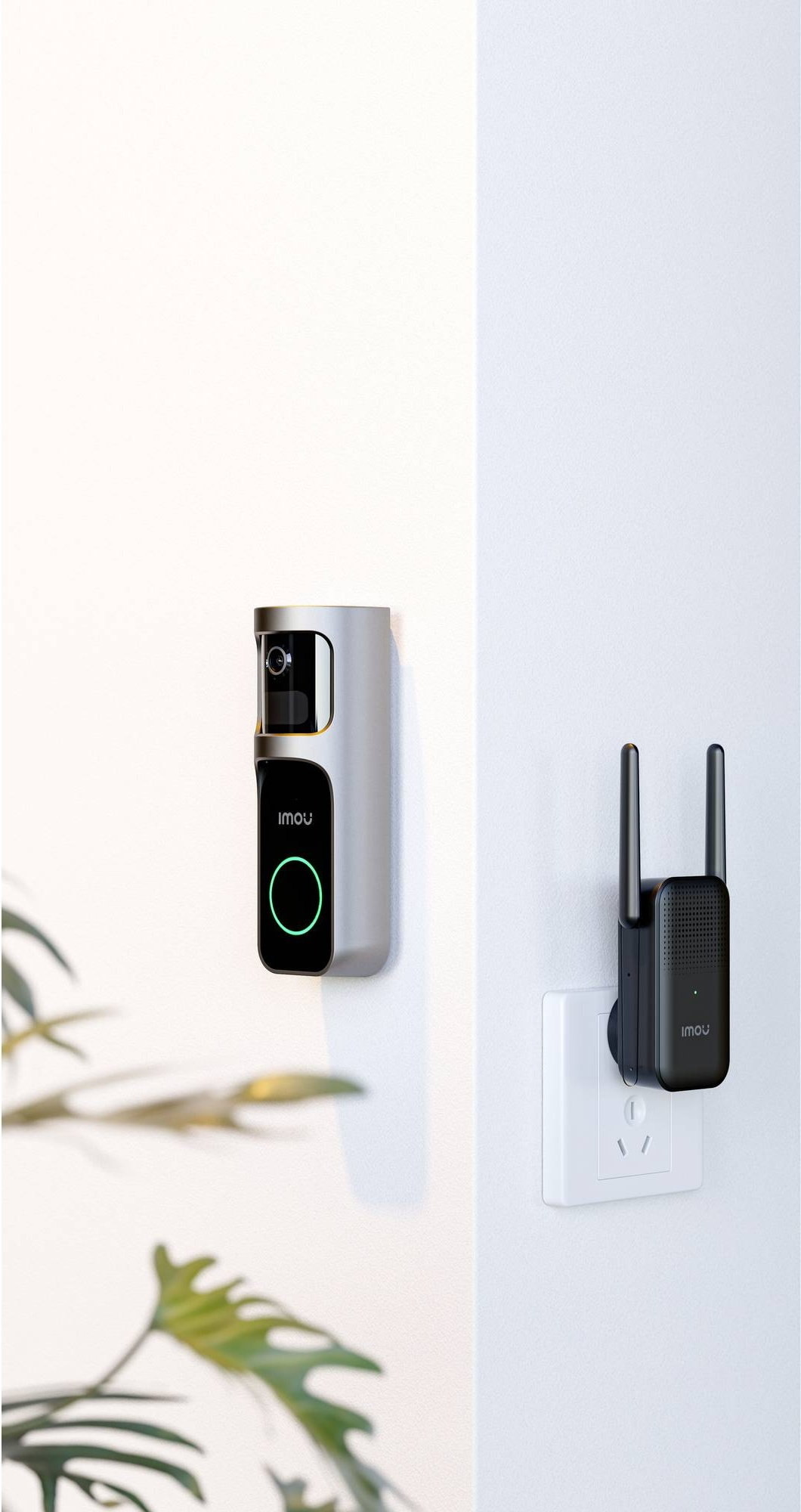 Eine silberne Videotürklingel an der Wand und ein schwarzer WLAN-Verstärker in einer Steckdose daneben.