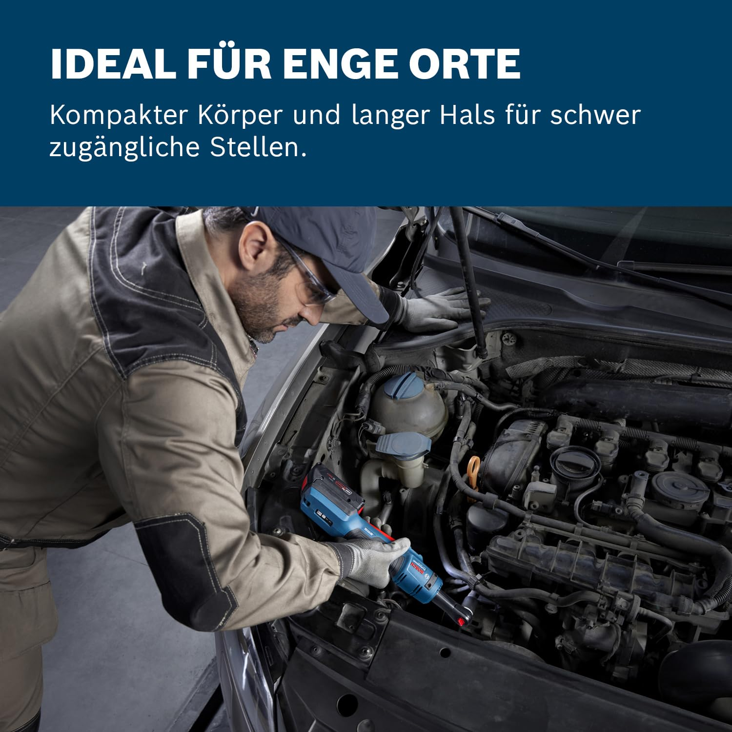 Mechaniker arbeitet mit einer blauen Bosch Akku-Winkelbohrmaschine im engen Motorraum eines Autos.