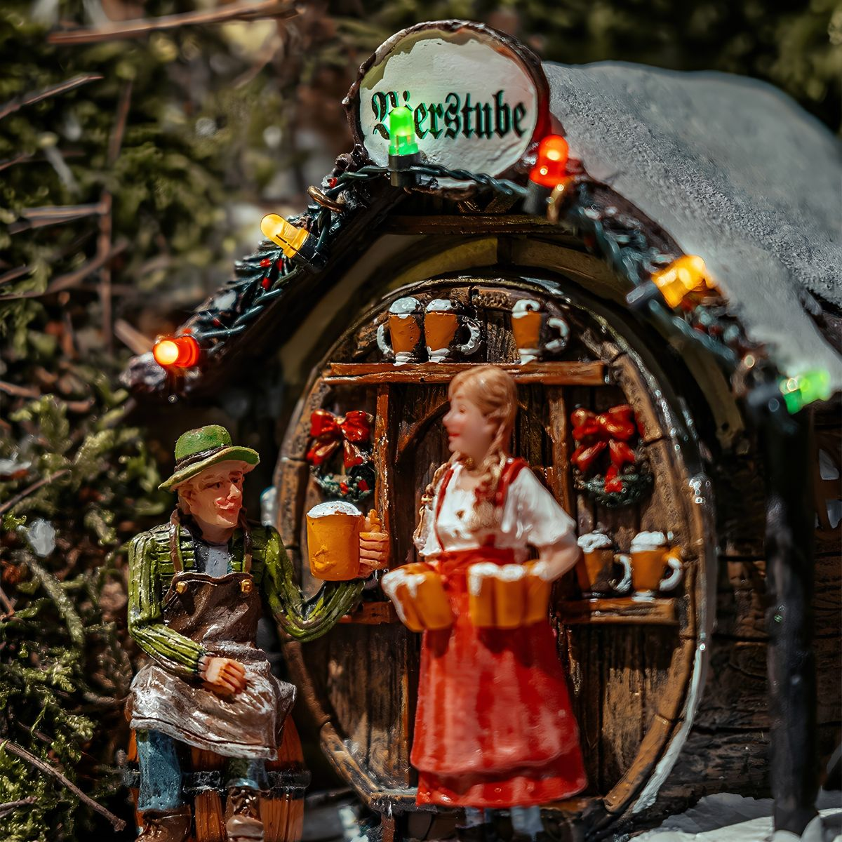 Miniatuurfiguren in een biërcafé, een vrouw serveert bier en een man zit buiten.