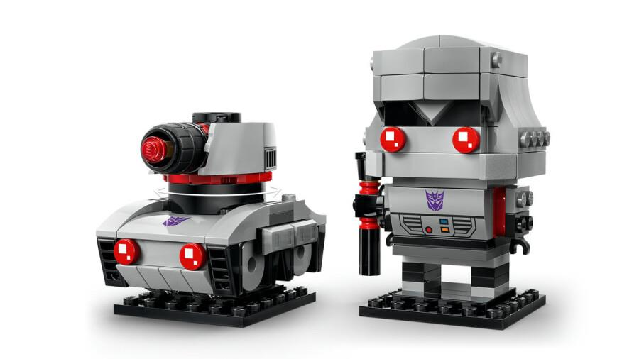 Siyah ayaklar üzerinde gri Lego Transformer robot figürü ve gri bir tank.