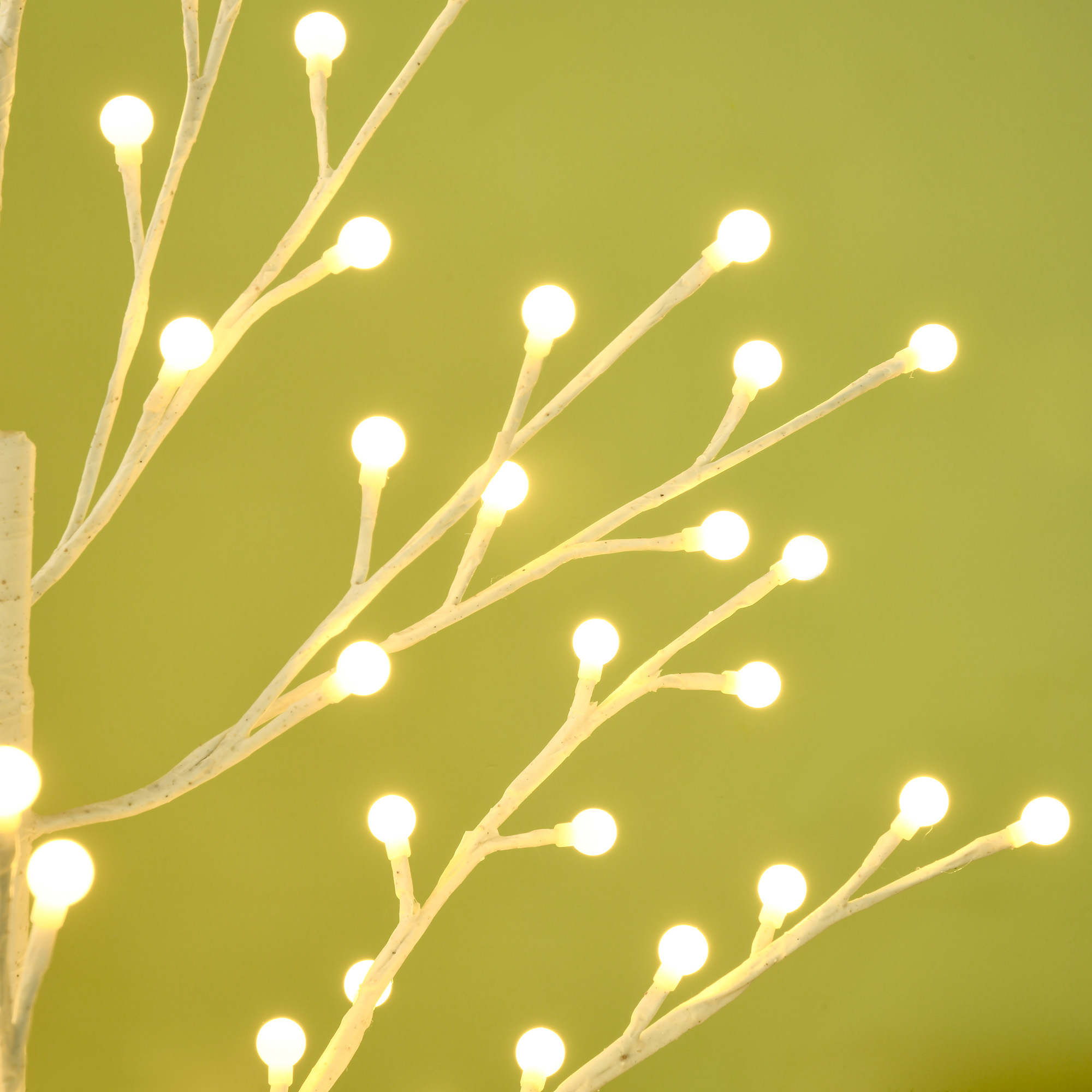 Ramas blancas iluminadas con pequeñas luces LED redondas sobre un fondo verde claro.