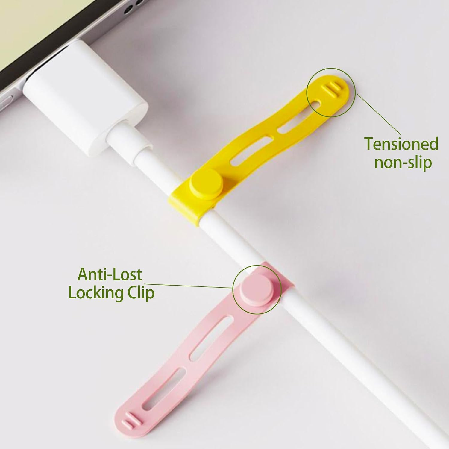 Ein weißes Ladekabel auf weißer Oberfläche mit gelbem rutschfestem Clip und rosa Verriegelungsclip.