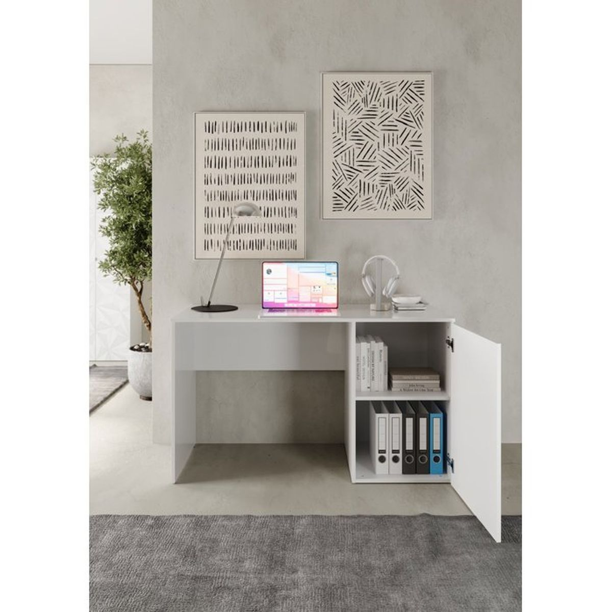 Ein weißer Schreibtisch mit Laptop, Lampe und offenem Schrank mit Ordnern vor einer Wand mit zwei abstrakten Kunstwerken.