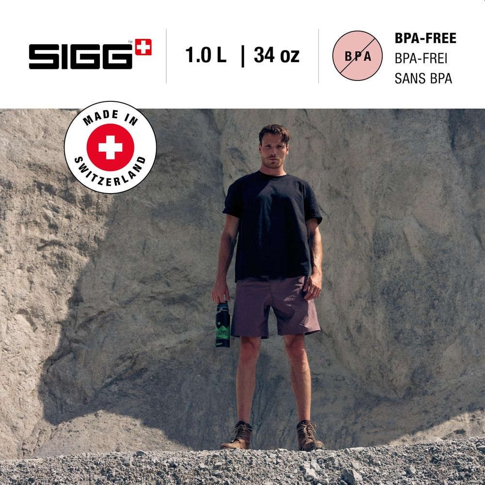 Ein Mann steht in Naturkleidung vor einer Felswand und hält eine SIGG-Flasche.