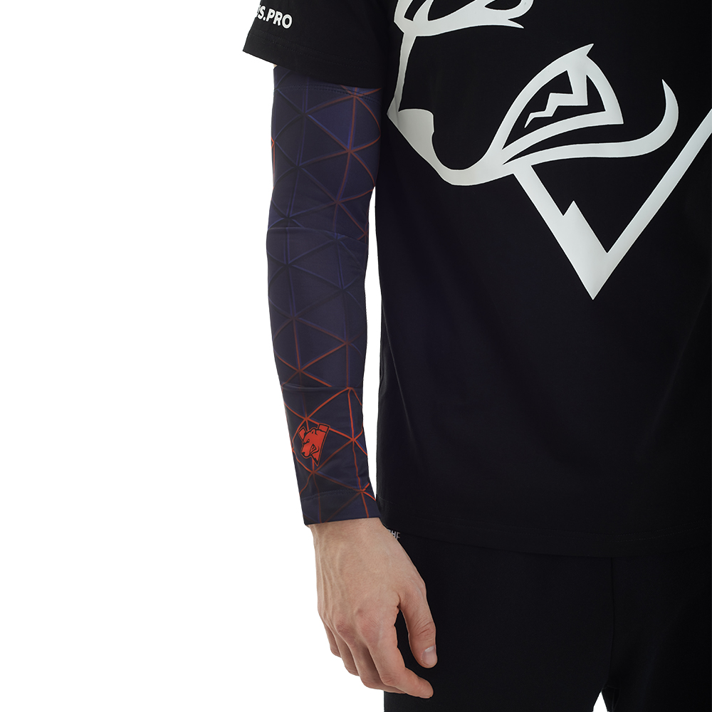 Eine Person trägt ein schwarzes T-Shirt und einen dunklen Armärmel mit geometrischem Muster.
