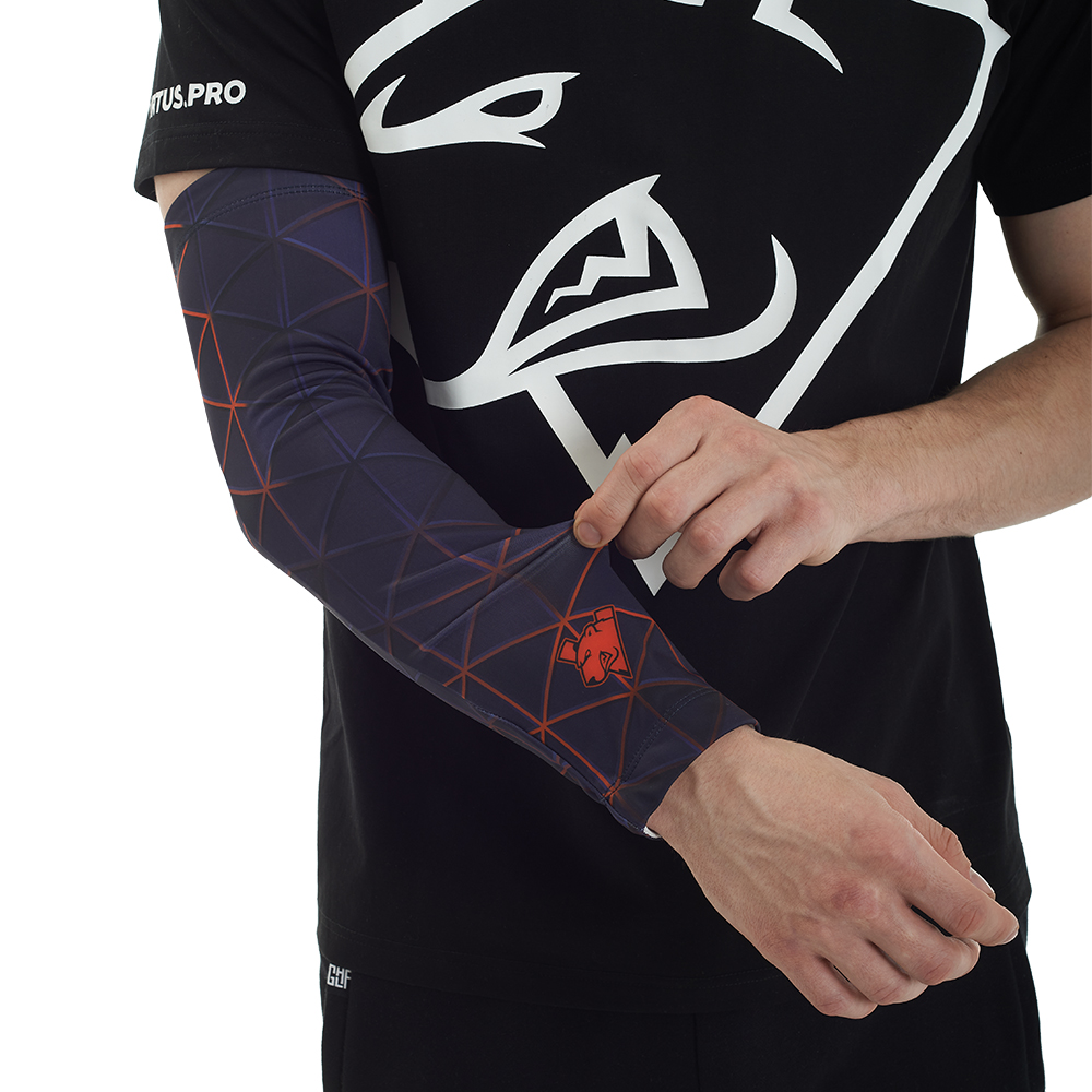 Ein Mann im schwarzen Shirt trägt einen dunklen Armling mit violettem geometrischem Muster und rotem Logo.