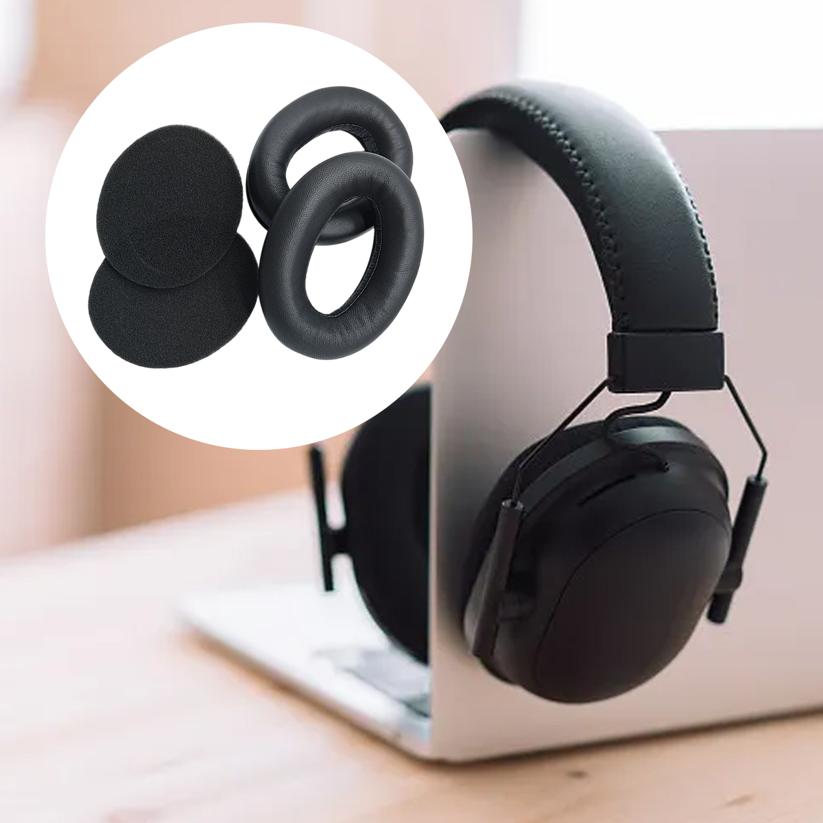 Schwarze Over-Ear-Kopfhörer auf einem Laptop-Ständer mit zwei Ersatz-Ohrpolstern im Kreis.