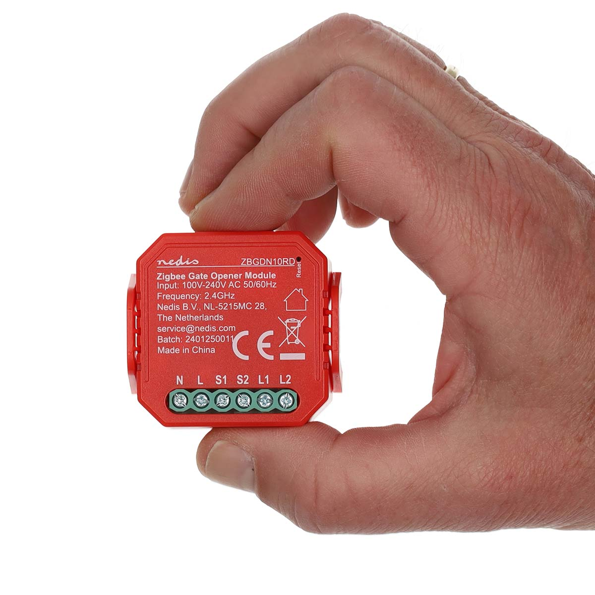 Eine Hand hält ein kleines rotes Nedis Zigbee Gate Opener Modul gegen einen weißen Hintergrund.