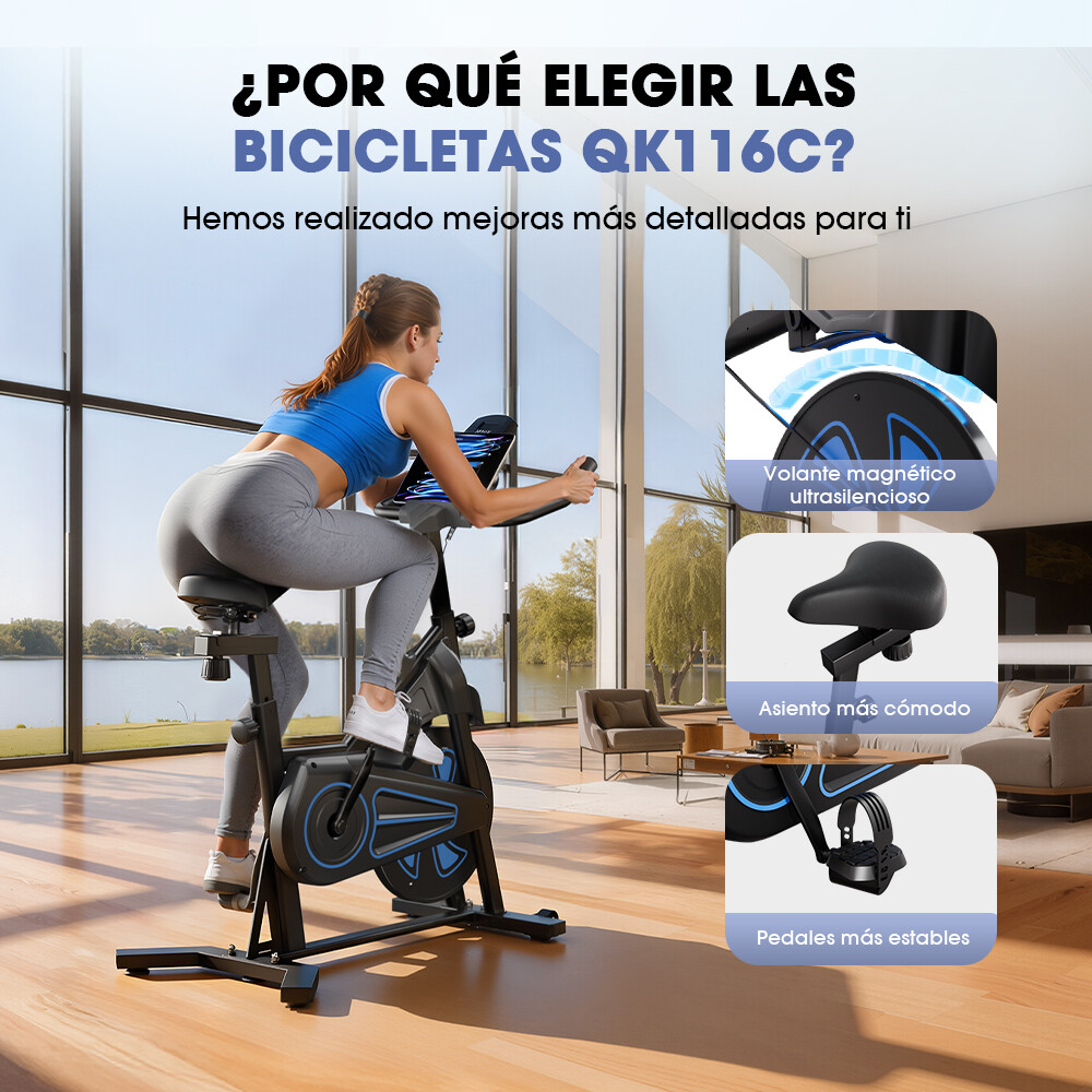 Una mujer hace ejercicio en una bicicleta estática en una habitación con grandes ventanales.